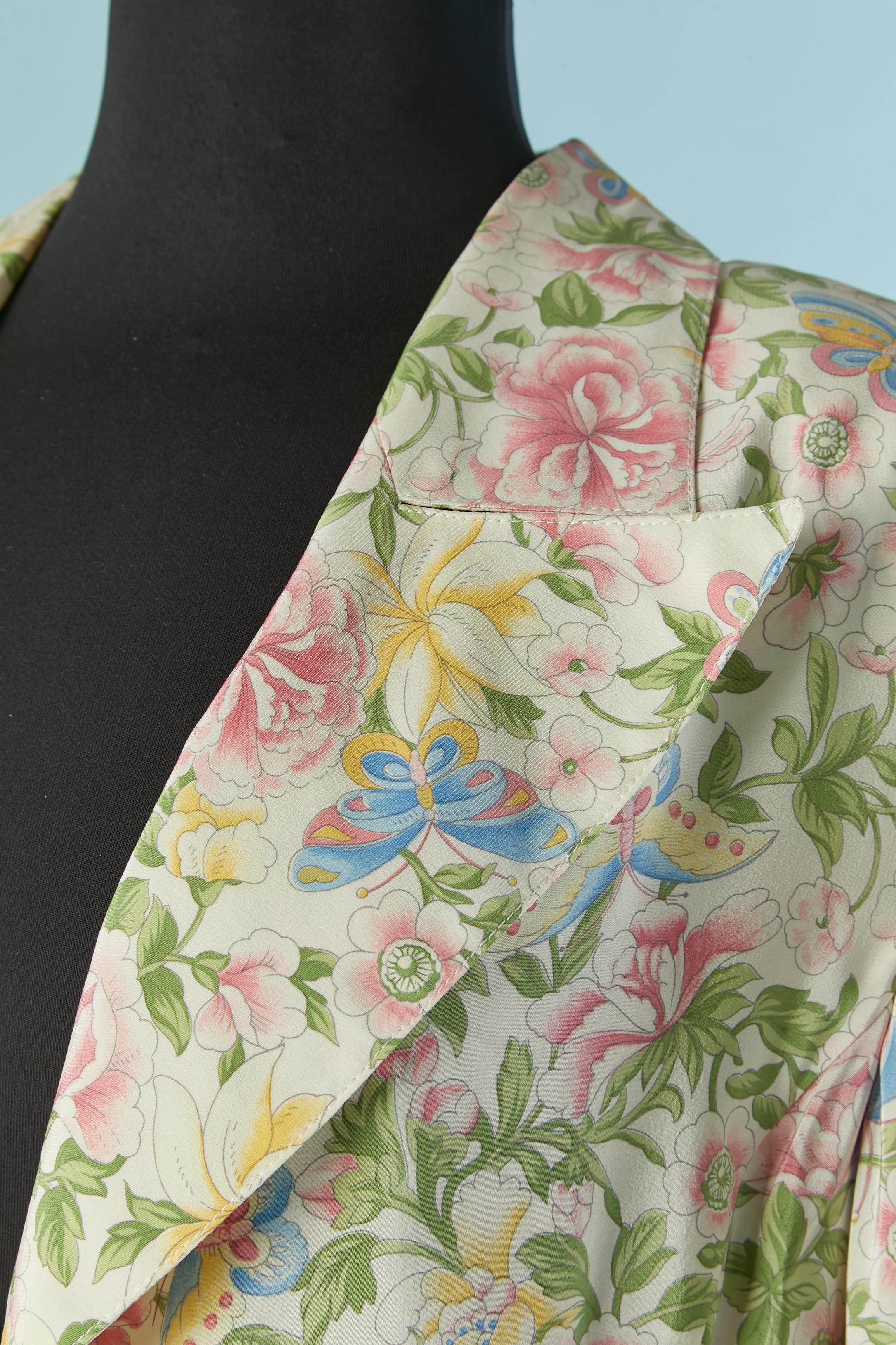 Seidenmantel mit Blumendruck und Knopf- und Knopflochverschluss in der vorderen Mitte. Tasche auf beiden Seiten. Gleiches Stofffutter. 
Schulterpolster. Auf der Mitte des Rückens geteilt, Länge = 30cm
GRÖSSE L 