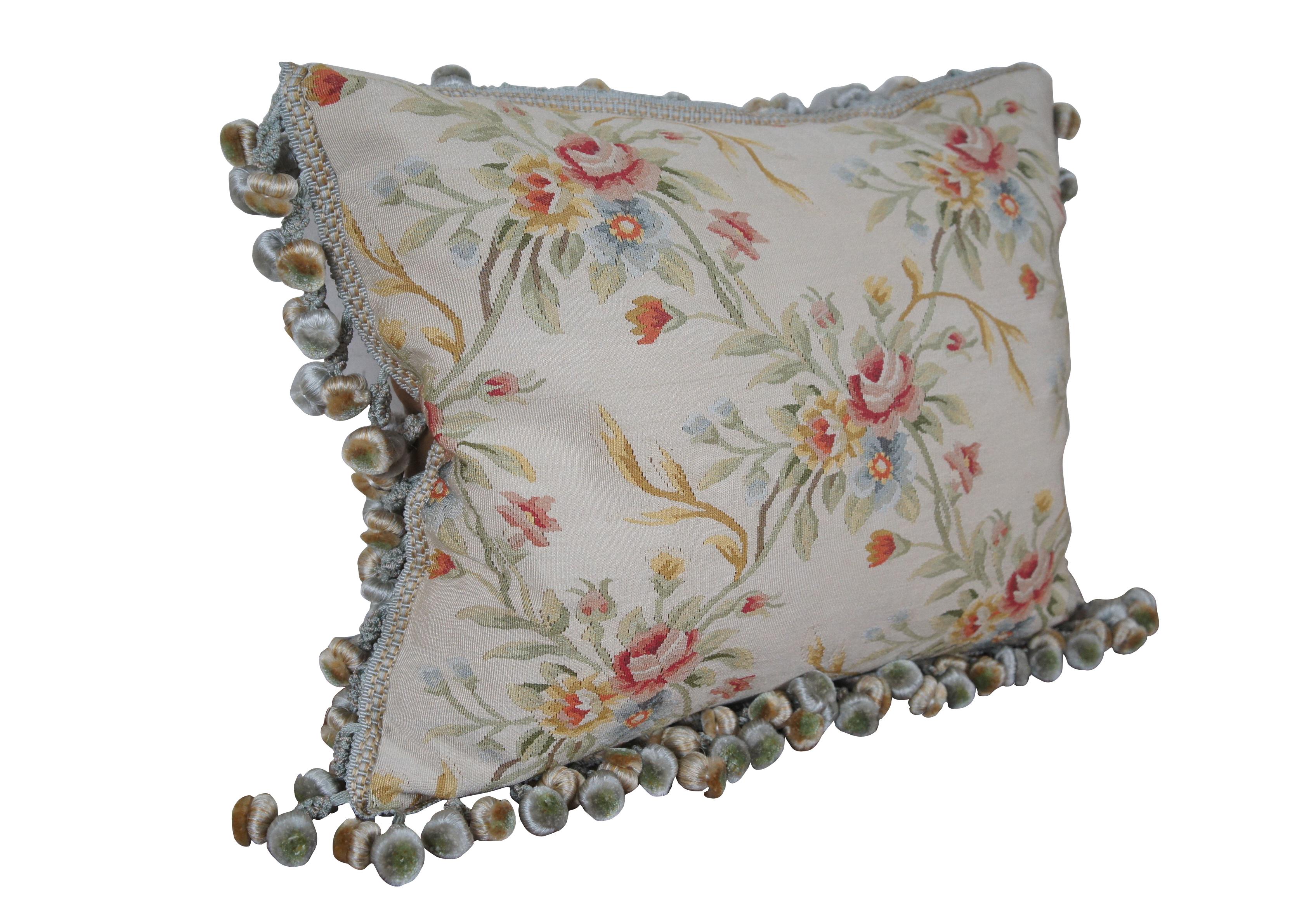 20th century rectangular lumbar / throw pillow,  embroidered in silk with bouquets of pink, yellow, blue and orange flowers, connected with green and yellow stems. Down filled. Light brown velour back with zipper closure. Blue and gold ball tassel