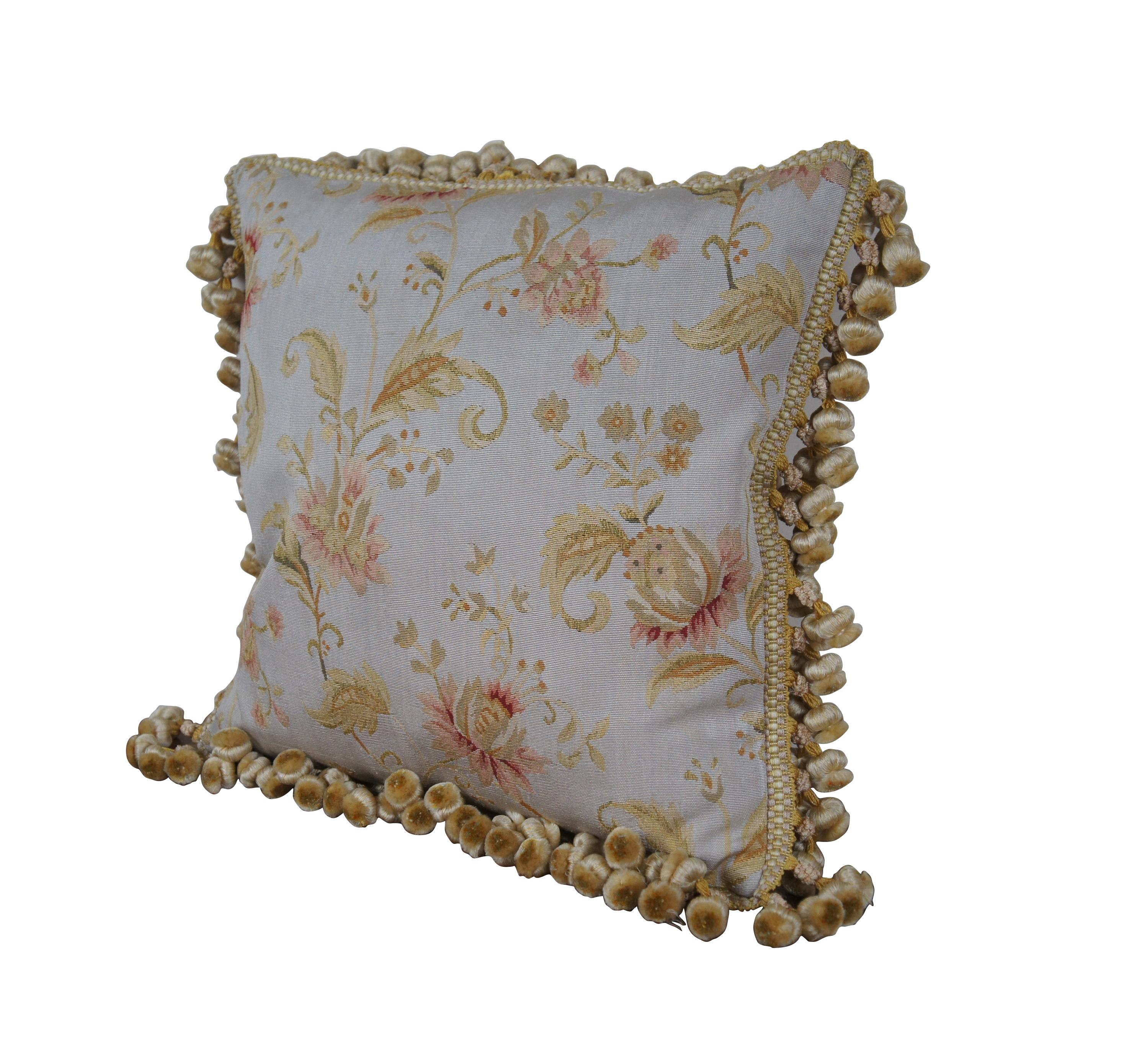 20th century square throw pillow, embroidered in silk with pale green-gold swirling leaves with large, pink lotus blossoms on a pale blue background.  Gold and cream ball tassel trim. Light brown velour back with zipper closure. Down filled. Made in