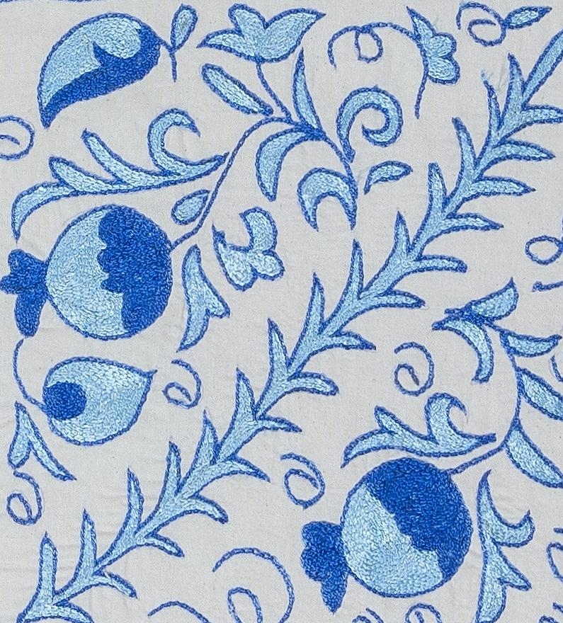 Fodera decorativa per cuscino realizzata in seta ricamata a mano su sfondo di lino, con motivi di fiori e viti, supporto di lino con cerniera, senza inserto.
Si consiglia un lavaggio delicato e specializzato.

Suzani, un termine dell'Asia