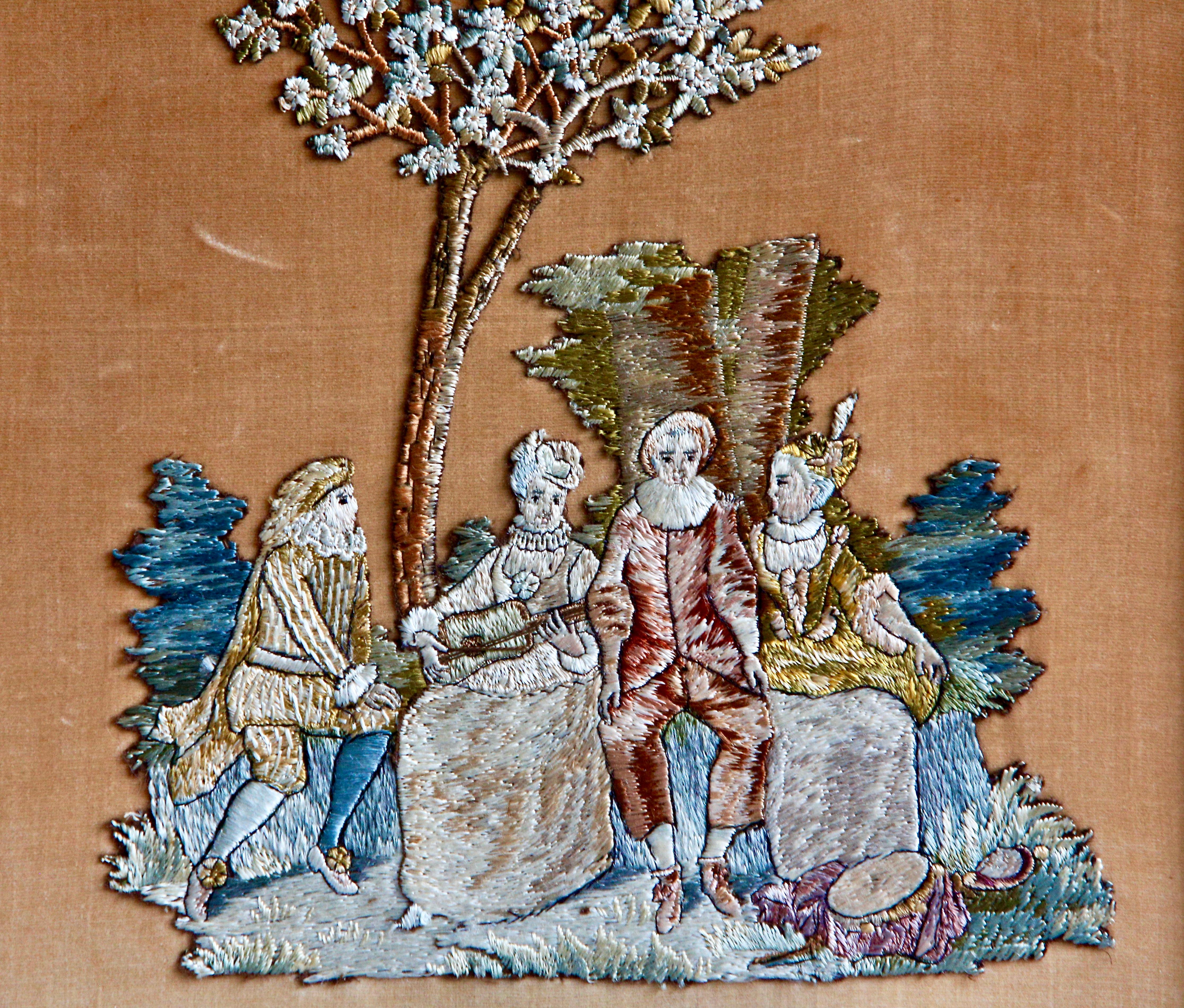 Panneau photo monté en broderie à l'aiguille sur soie 

Un travail à l'aiguille continental représentant des personnages dans un cadre romantique sur un fond rural dans un cadre ébonisé et doré monté avec une bordure marbrée rouge et or. 