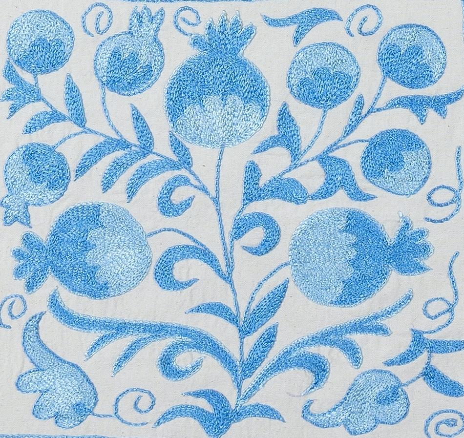 Fodera decorativa per cuscino realizzata in seta ricamata a mano su sfondo di lino, con motivi di fiori e viti, supporto di lino con cerniera, senza inserto.
Si consiglia un lavaggio delicato e specializzato.

Suzani, un termine dell'Asia
