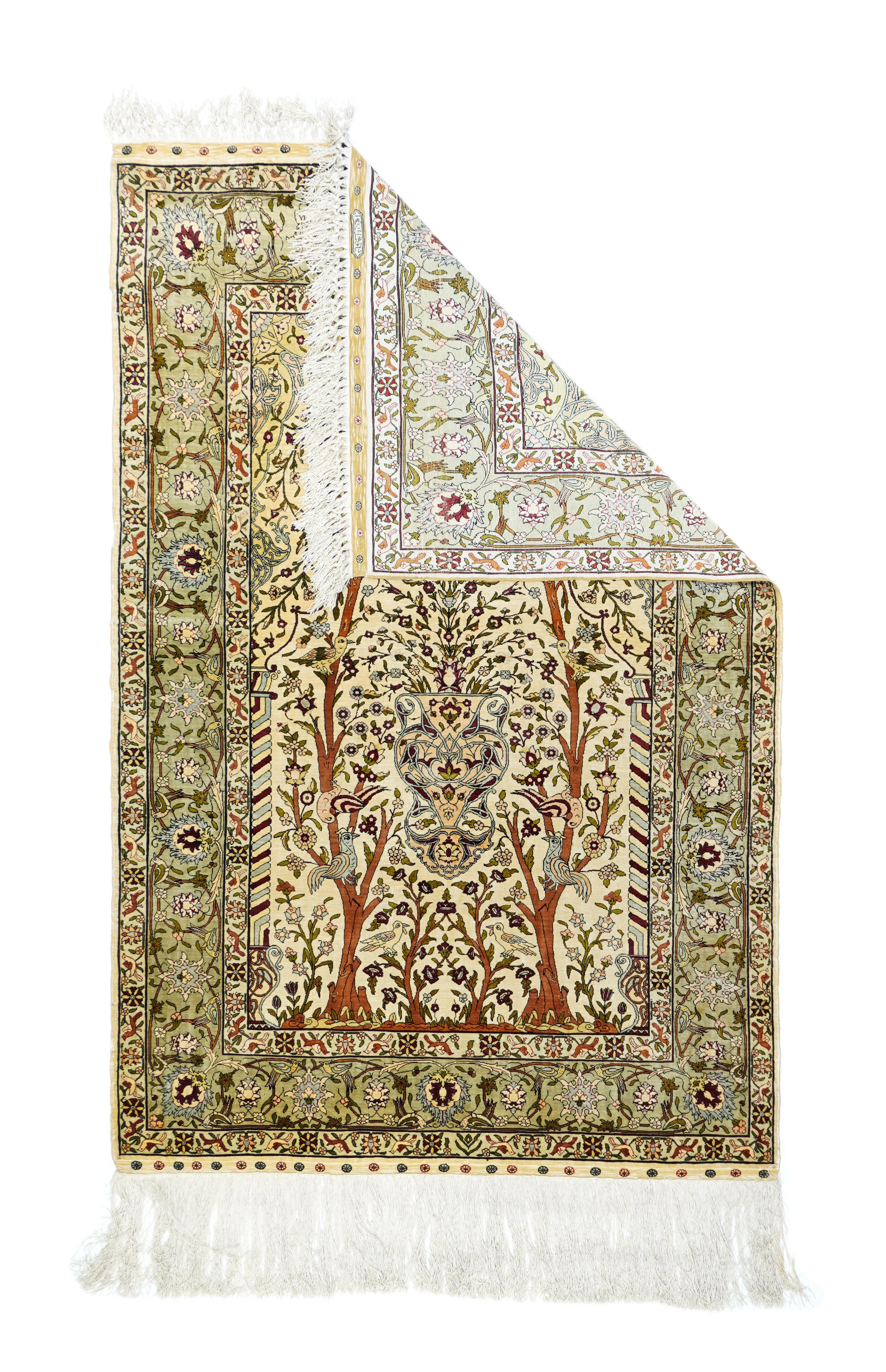 This all silk, extremely fine urban, Turkish wall-hanging shows a cream nichewith a central vase flanked by two full-height trees harboring small birds. Diagonally colour-ribbed colonettes at the sudes. Light straw spandrels with vineryand forked