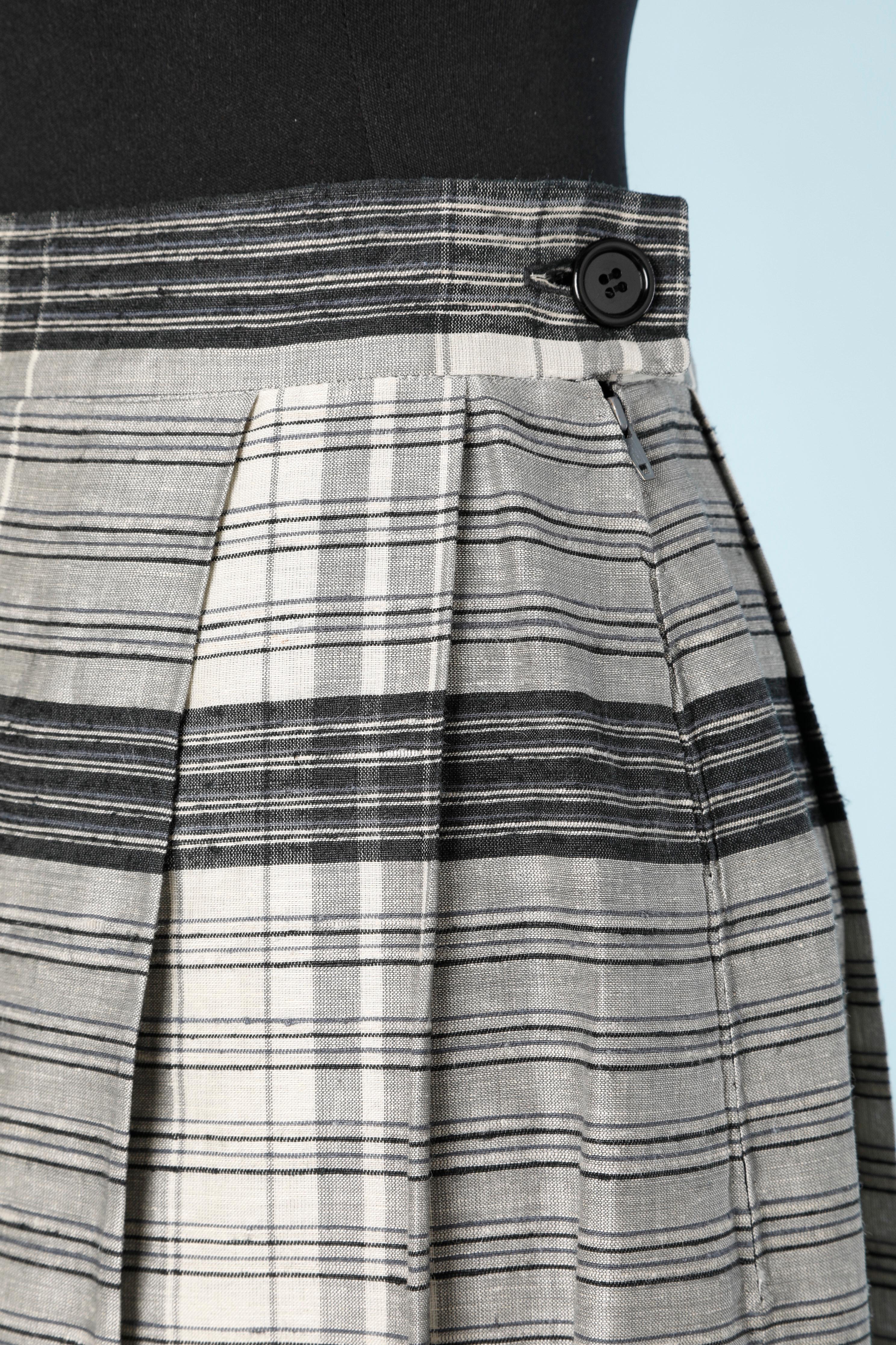 Jupe plissée en jacquard de soie avec motif à carreaux ; pas de doublure. Fermeture à glissière, bouton et boutonnière sur le côté gauche. 
TAILLE 34 (Fr) XS 