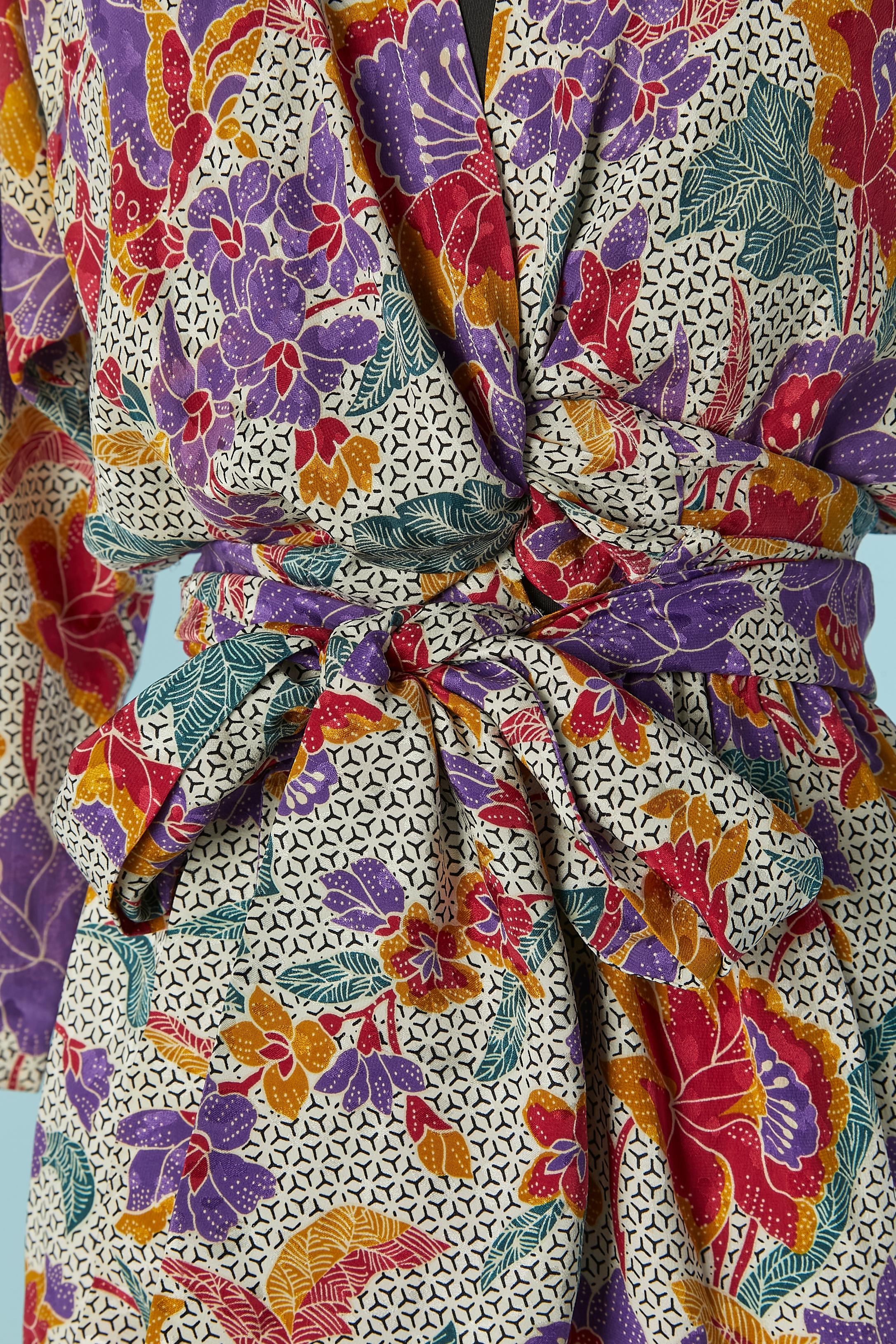 Robe enveloppante en jacquard de soie imprimé sur le haut. Doublure en rayonne blanche à l'intérieur de la jupe. Fermeture à glissière sur le côté gauche. Pochette sur les deux côtés. Pad d'épaule. 
Taille sur l'étiquette 34 (Fr) mais convient à 36