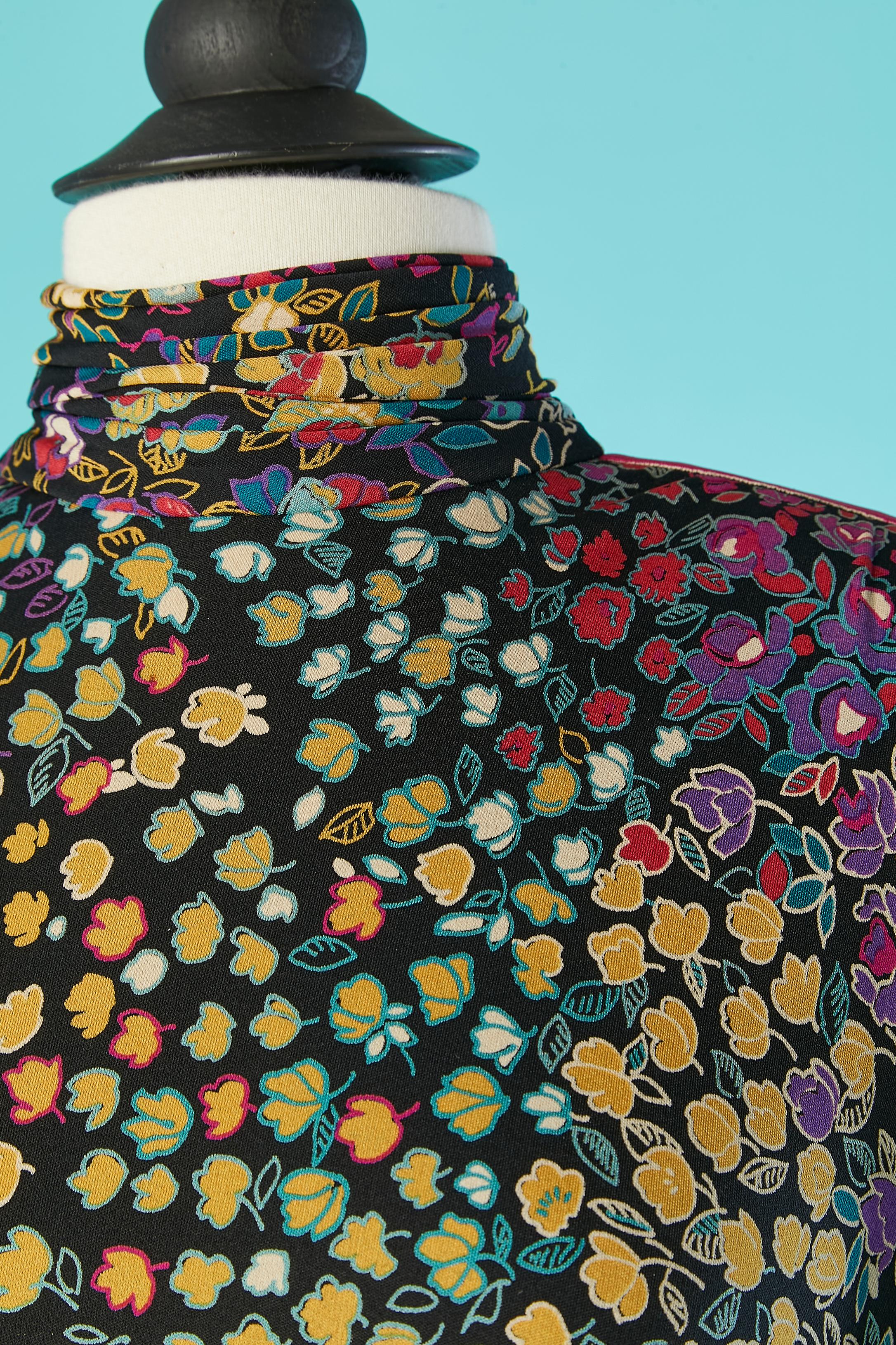 Robe en jersey de soie à imprimé floral. Drapée au col, aux poignets et à la taille. Fermeture à glissière au milieu du dos et fermeture à glissière sur le côté gauche des hanches + bouton pression. Bande élastique à l'intérieur de la taille avec