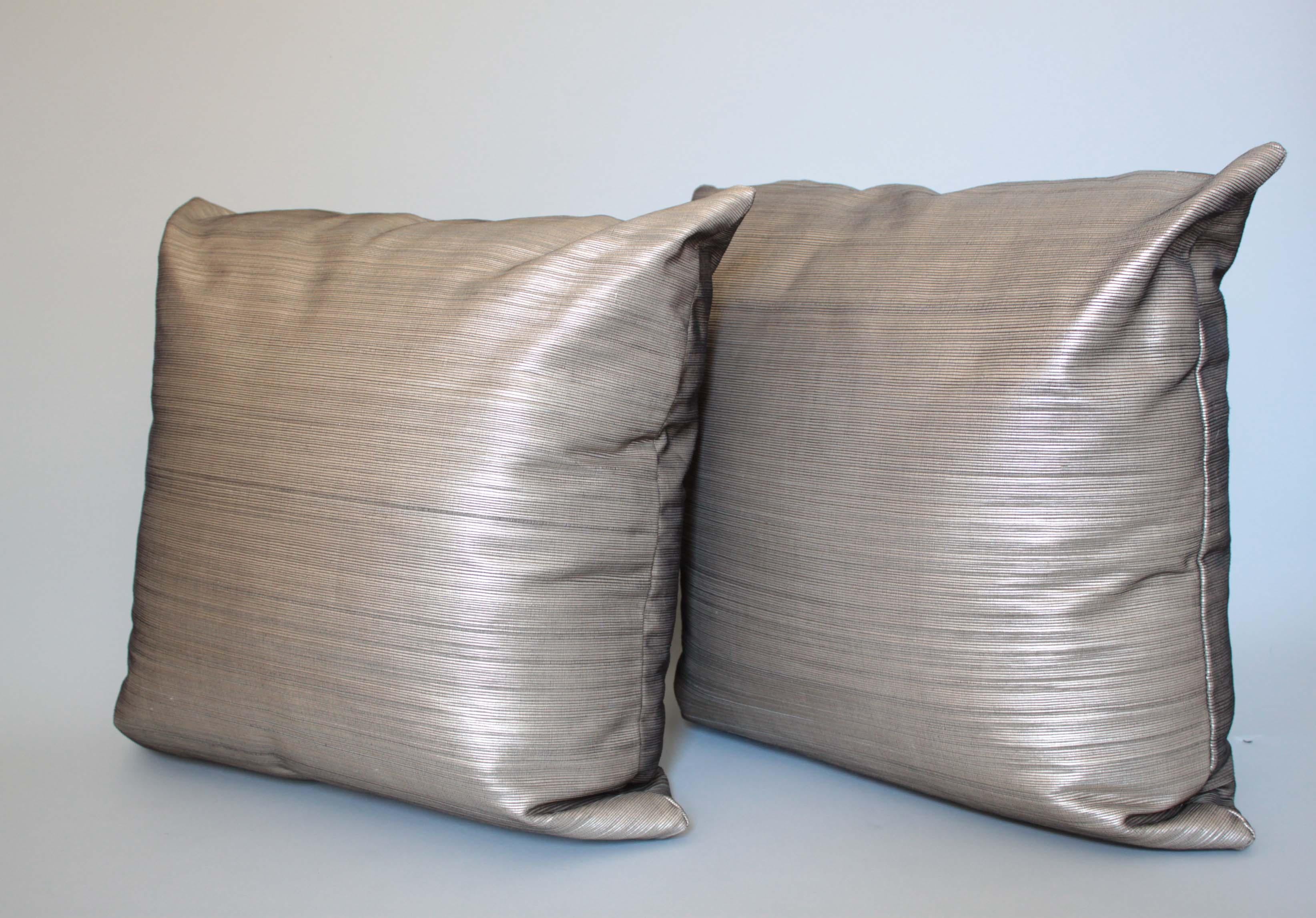 Silk & platinum metallic leather pillows with down-free inserts. 
They are wonderfully constructed in the Philippines by talented textile weavers. 
Pillows by Stationhaus.