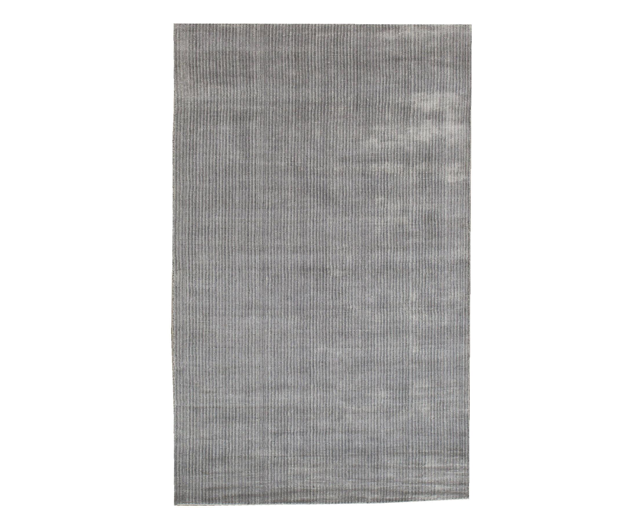 Handmade silk pile on a cotton foundation.

Dimensions: 5' x 8'. 

Origin: India

Field Color: Grey.