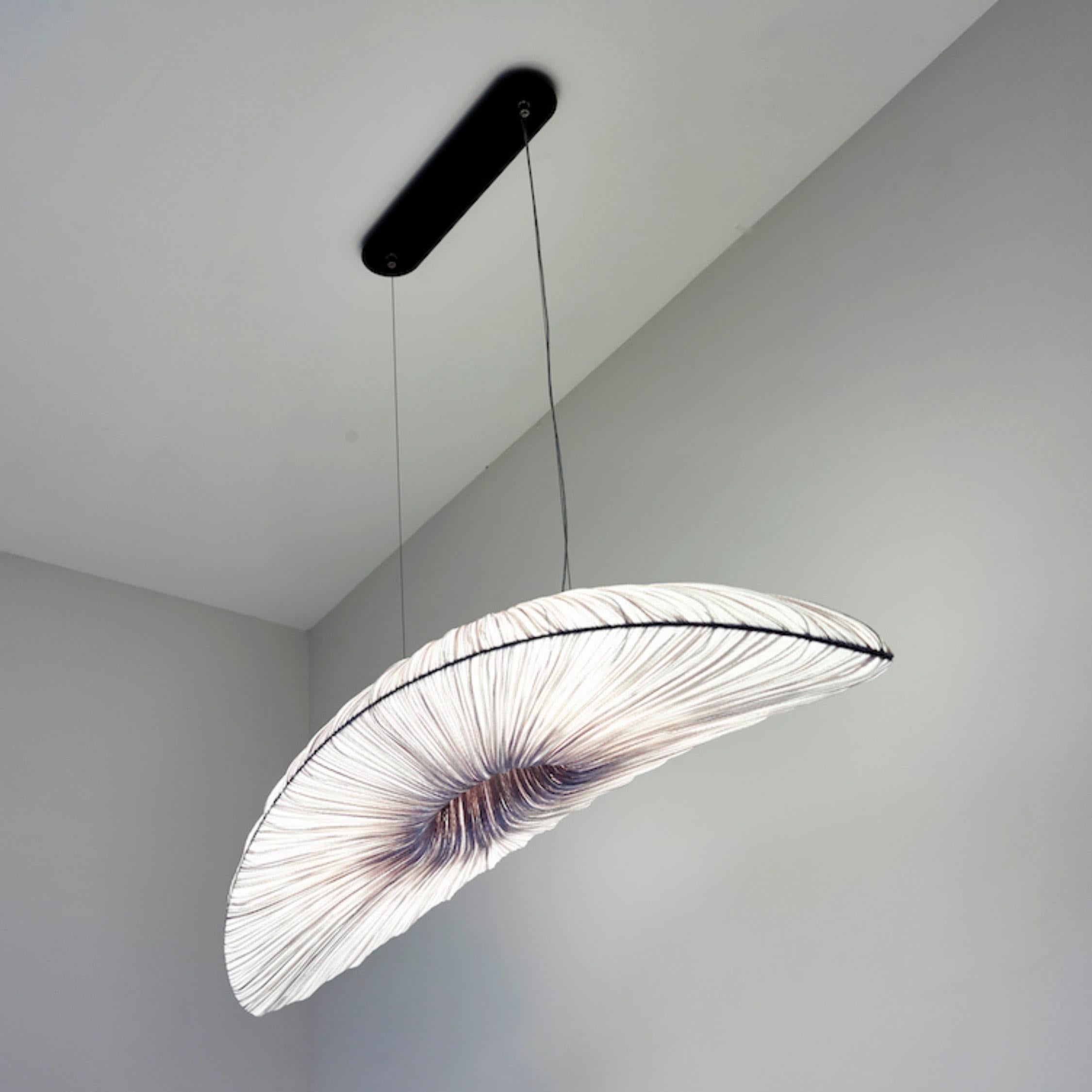 The liana S pendant light is the perfect addition to a dining room or kitchen. Part of the Orchestra Family, its concave form is inspired by natural shapes found in music, as well as contemporary sculpture and architecture. The hanging pendant is