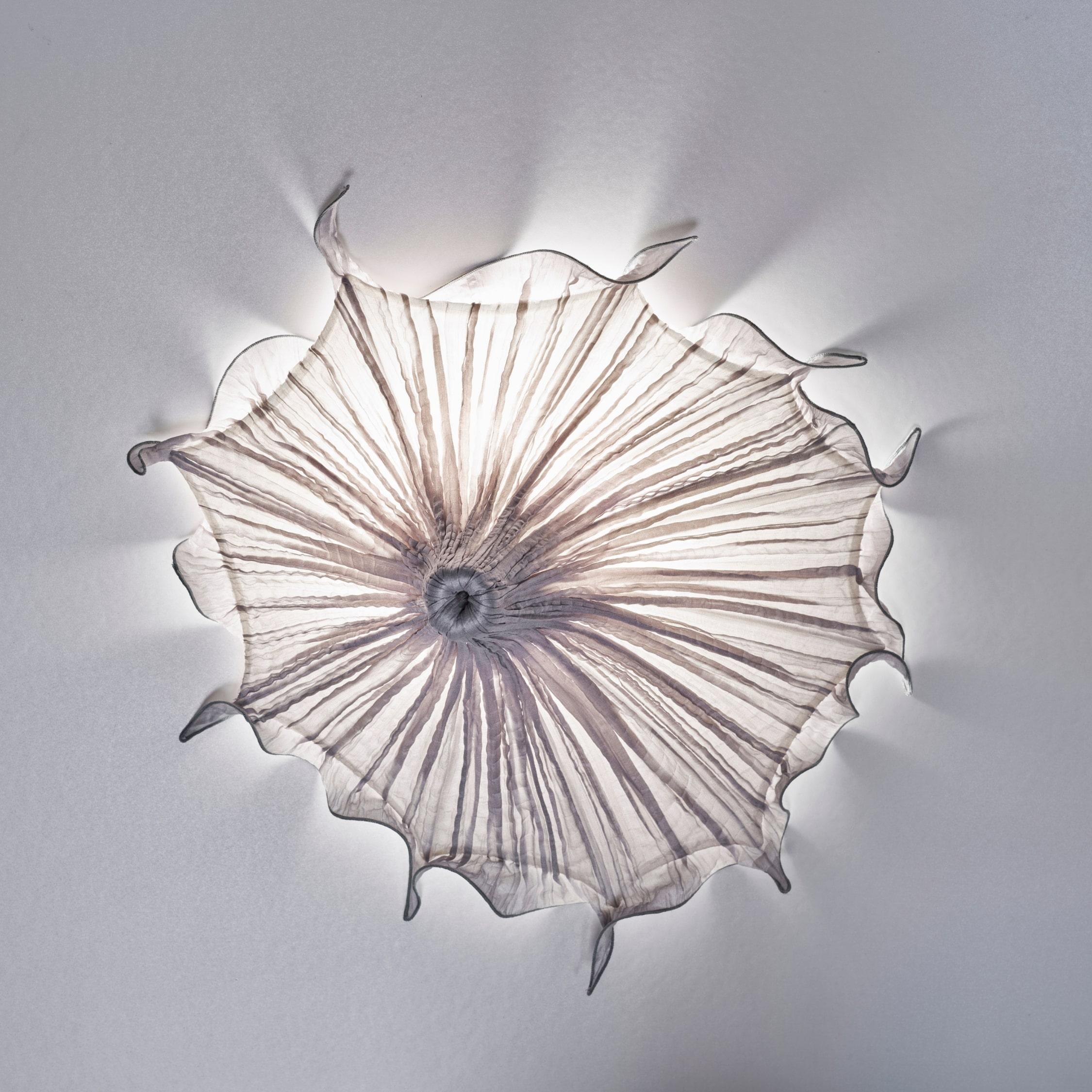 The Medusa wall lamp creates a mesmerizing halo lighting effect, adding drama to any room. It is part of the Morning Glory Family, of lighting fixtures, whose elegant shapes are inspired by highly stylized organic forms, including exotic flowers and