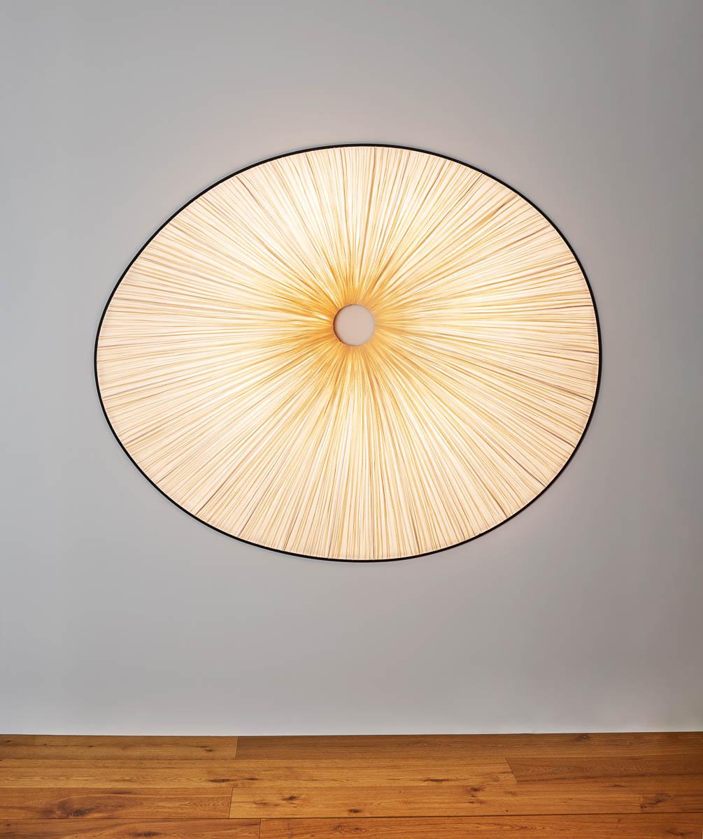 The Sahara wall fixture has a rounded sculptural form that casts a halo of light across the ceiling or wall it is mounted on to dramatic effect. It is part of the Orchestra Family, inspired by natural musical forms as well as modern sculpture and
