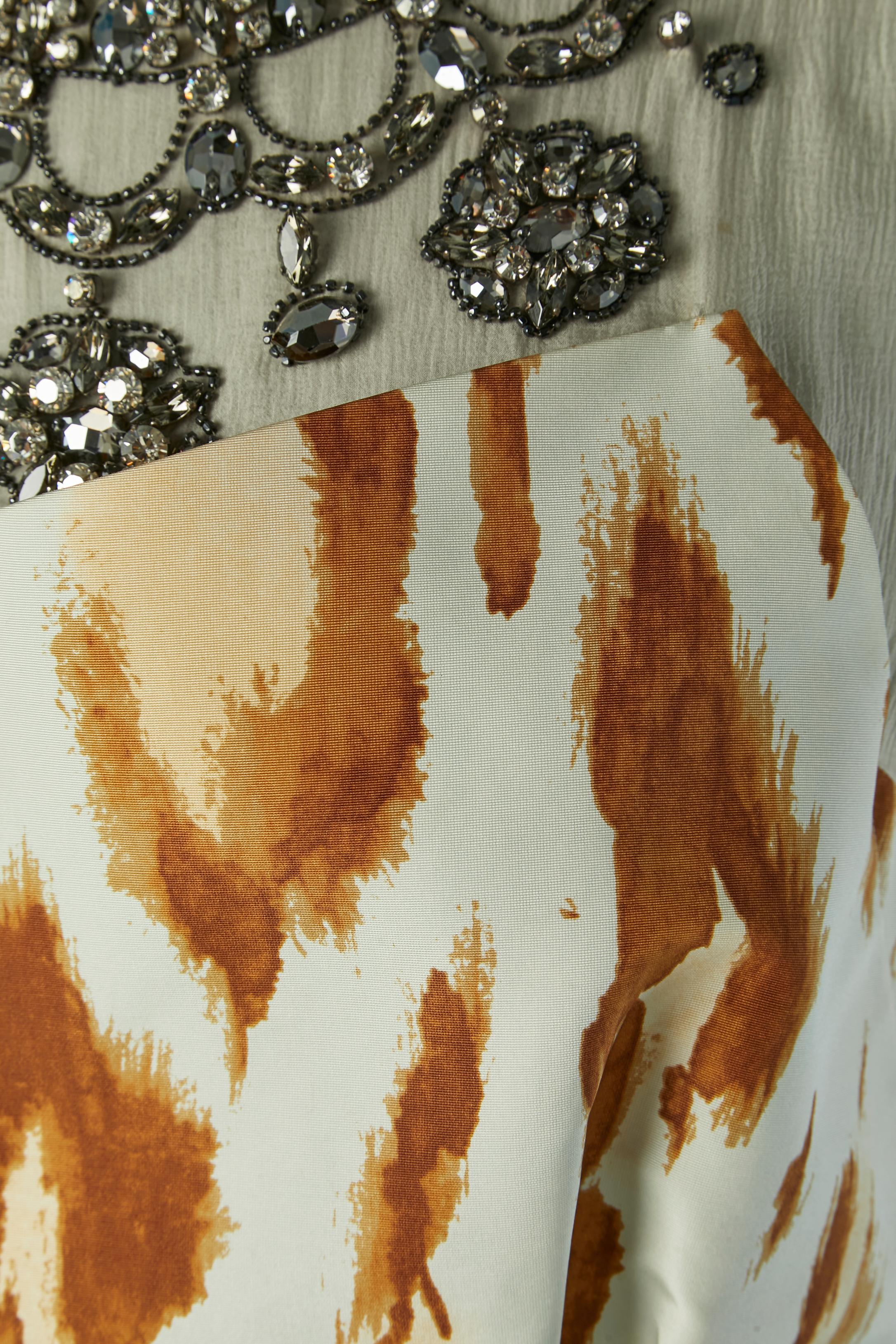 Abito da cocktail bustier stampato su un abito in chiffon di seta con colletto impreziosito da strass. Fodera in seta. Zip invisibile e gancio sul lato sinistro. I ricami sono realizzati in vetro e metallo. 
Un bottone e un'asola in tessuto sulla