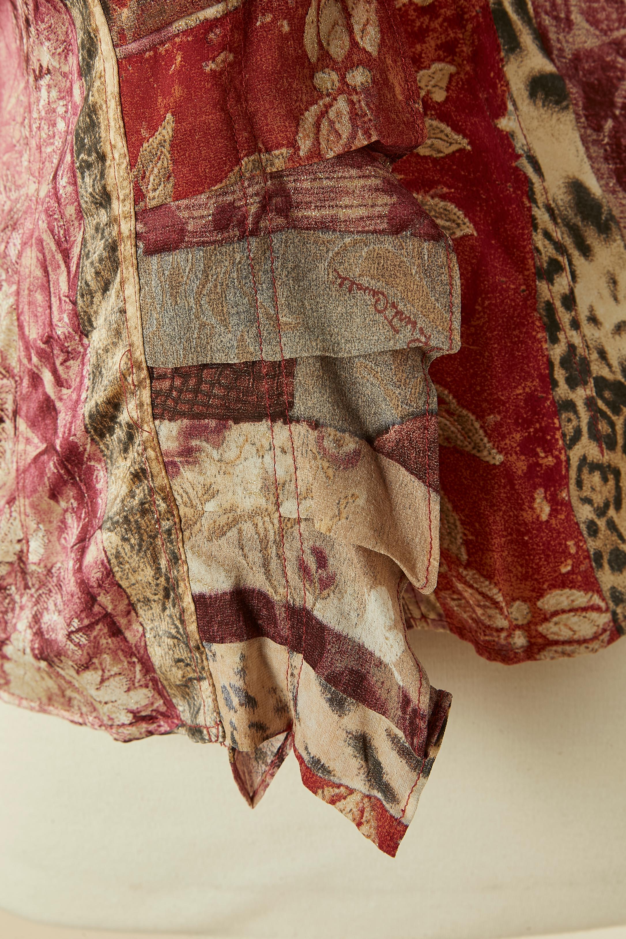 Chemise en soie imprimée avec jabot et nœud sur le devant terminé par une chaîne et des perles. Bouton et boutonnière marqués sur les poignets. Hologramme d'authenticité.
TAILLE 44 (I.L) 40 (Fr) L 
