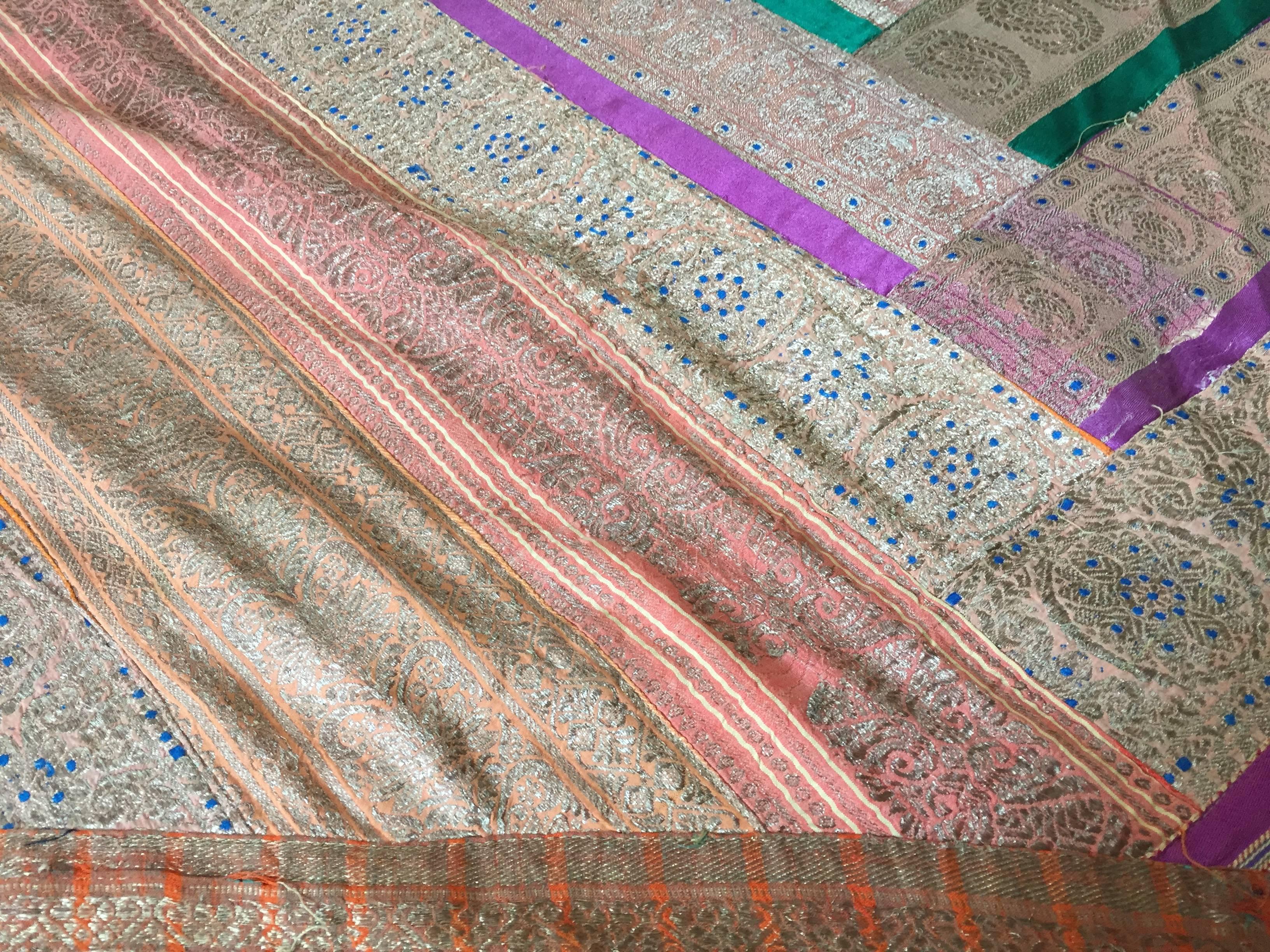 Seiden-Saire-Wandteppich-Patchwork aus maurischer Seide.
Handgefertigte Steppdecke aus antiken indischen Saris-Bordüren im Vintage-Stil.
Streifenstreifen Seidenstücke in mehrfarbigen, leuchtenden Farben mit goldfarben gestreiften Quadraten aus