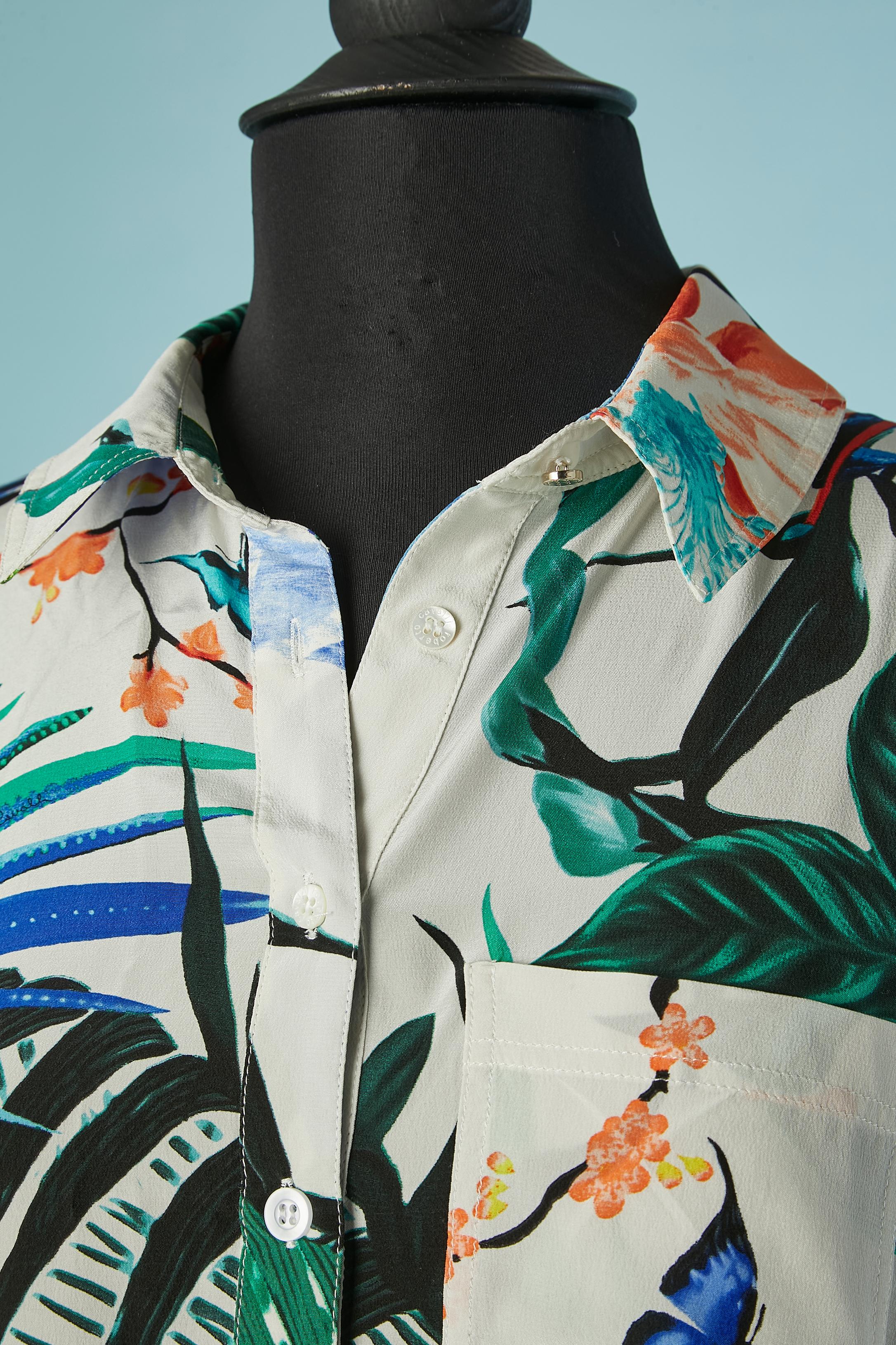Chemise-polo-dress en soie à imprimé jungle. Fermeture par boutons et boutonnières sur le milieu supérieur du devant. Bande élastique au milieu du dos sur la taille. 
Nouveau avec étiquette 
TAILLE 38 (Fr) M/ L. 