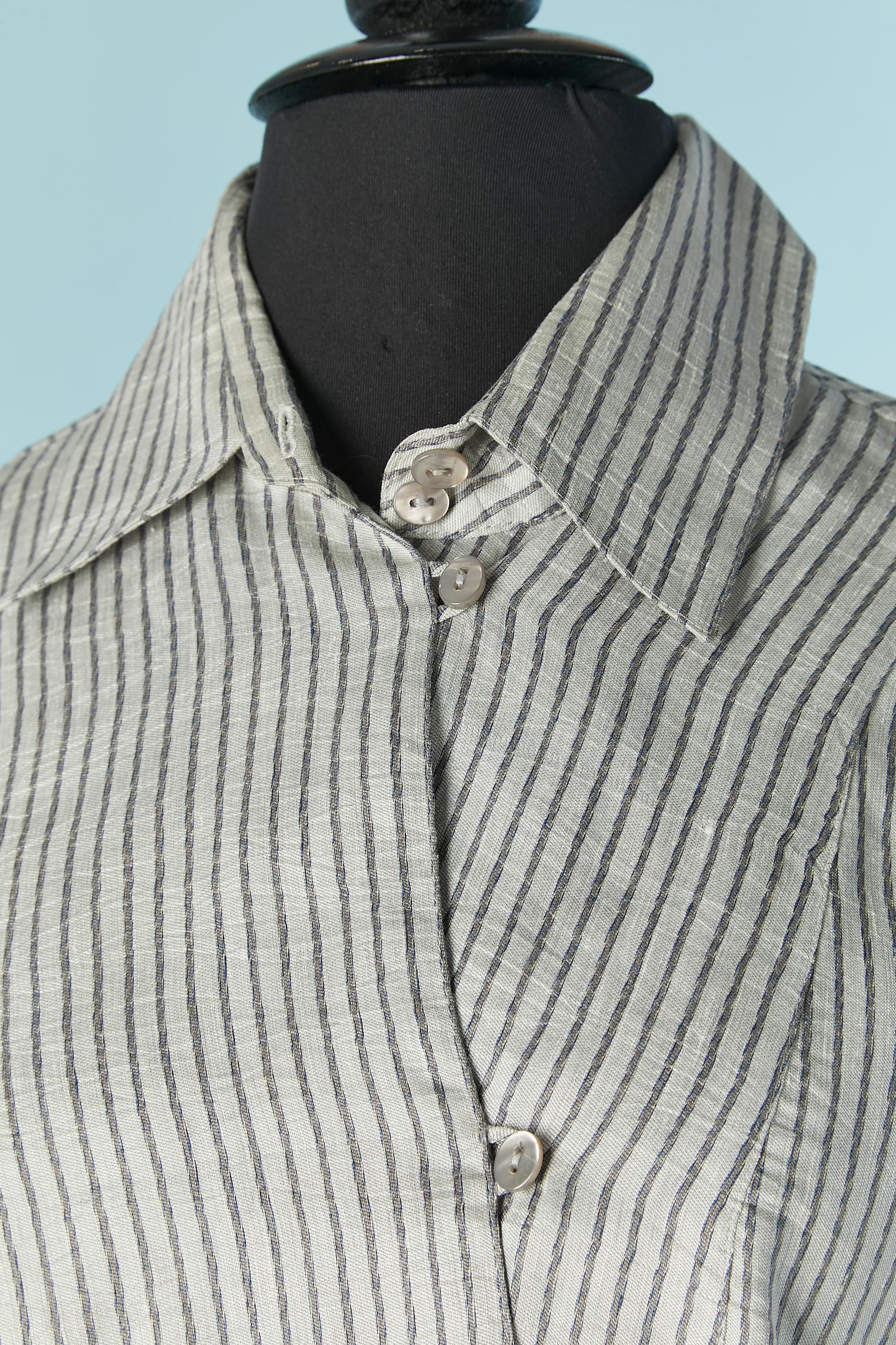 Camicia in seta a righe con linea asimmetrica di bottoni sul davanti. Chiusura con bottoni e asole sul davanti  e sui polsini. Viene fornito un pulsante extra. Chiusura con zip invisibile sul lato sinistro. Divisa su entrambi i lati.
Taglia M 
