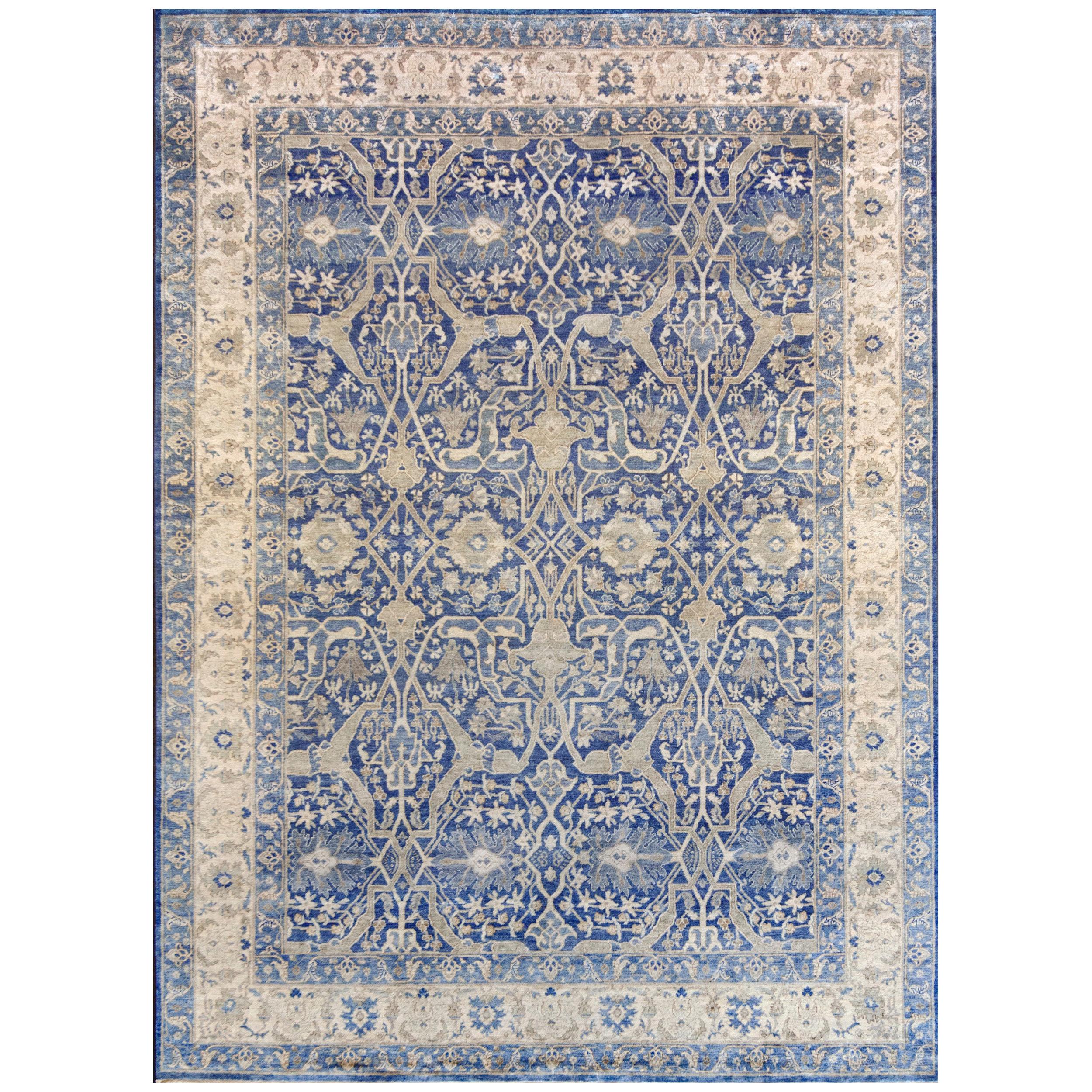 This handwoven silk Persian Tabriz rug has a shaded royal-blue field with and overall design of bold sandy-brown and ivory vine linking palmettes and delicate floral and leafy-vine, in an ivory border of light brown palmette and floral vine between