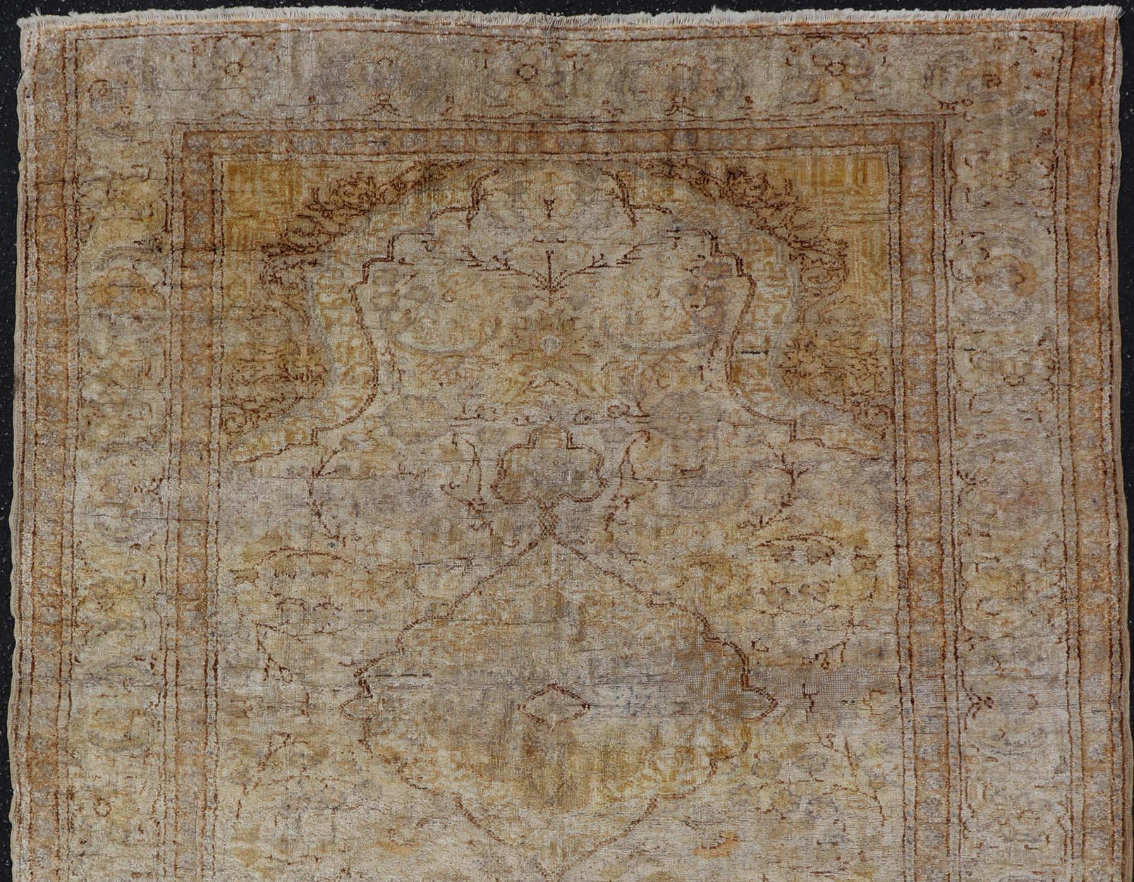 Alfombra turca Sivas con medallón central en tonos marfil, marrón y amarillo, alfombra dur-95073, país de origen / tipo: Turquía / Oushak, hacia mediados del siglo XX.

Esta alfombra turca vintage de Sivas (hacia mediados del siglo XX) presenta un