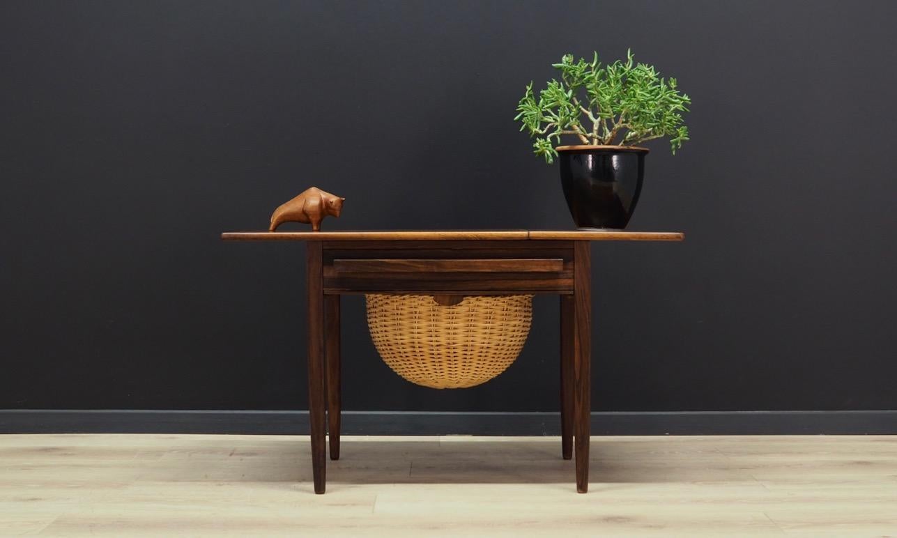 A fantastic sewing table from the 1960s-1970s. Scandinavian design, Minimalist form. Designed by Johannes Andersen, manufactured by CFC Silkeborg. The furniture finished with rosewood veneer. Foldable top, rattan basket and practical drawer for