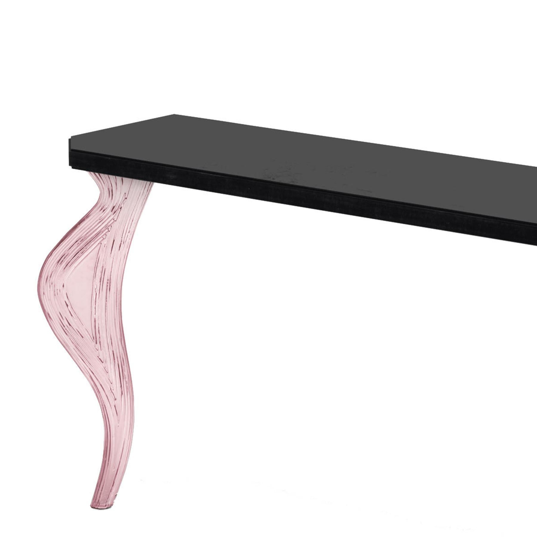 Wall console table Sillage rose with solid wood top
in black gloss lacquered finish. With 2 feet in extra light
fused glass in rose finish.