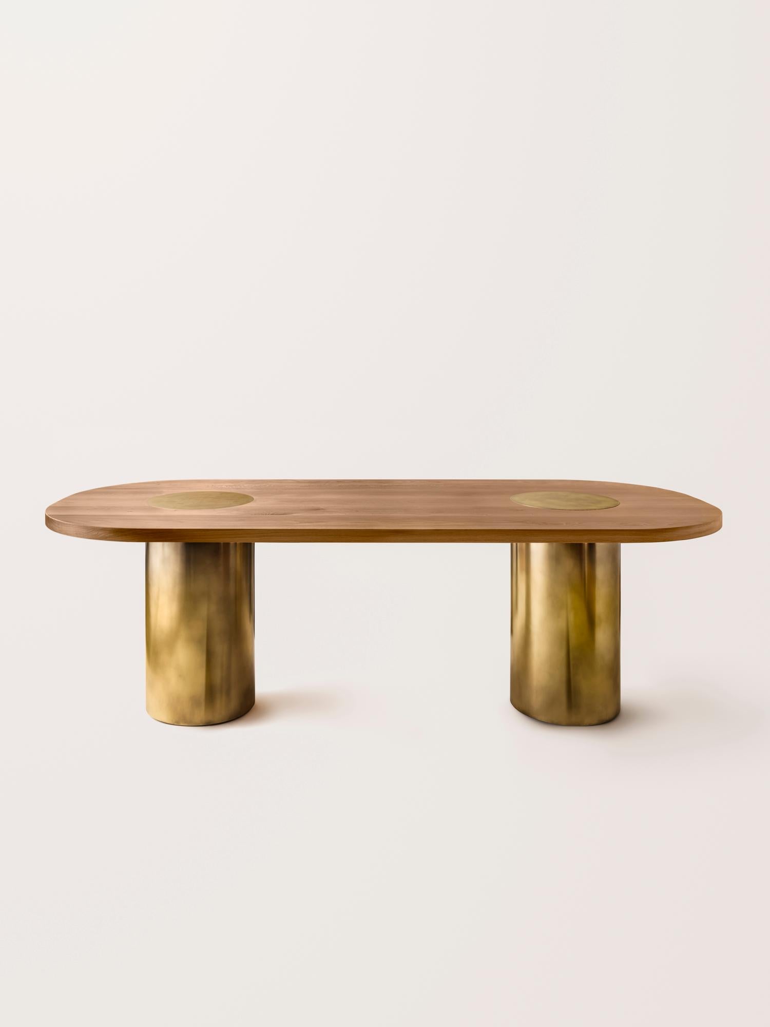 Inspired by the form and function of grain silos, the sculptural Silo Dining Table features solid wood and hand-finished brass or stainless steel wrapped legs.

This listing does NOT include the two brass domes that are pictured in some images, they