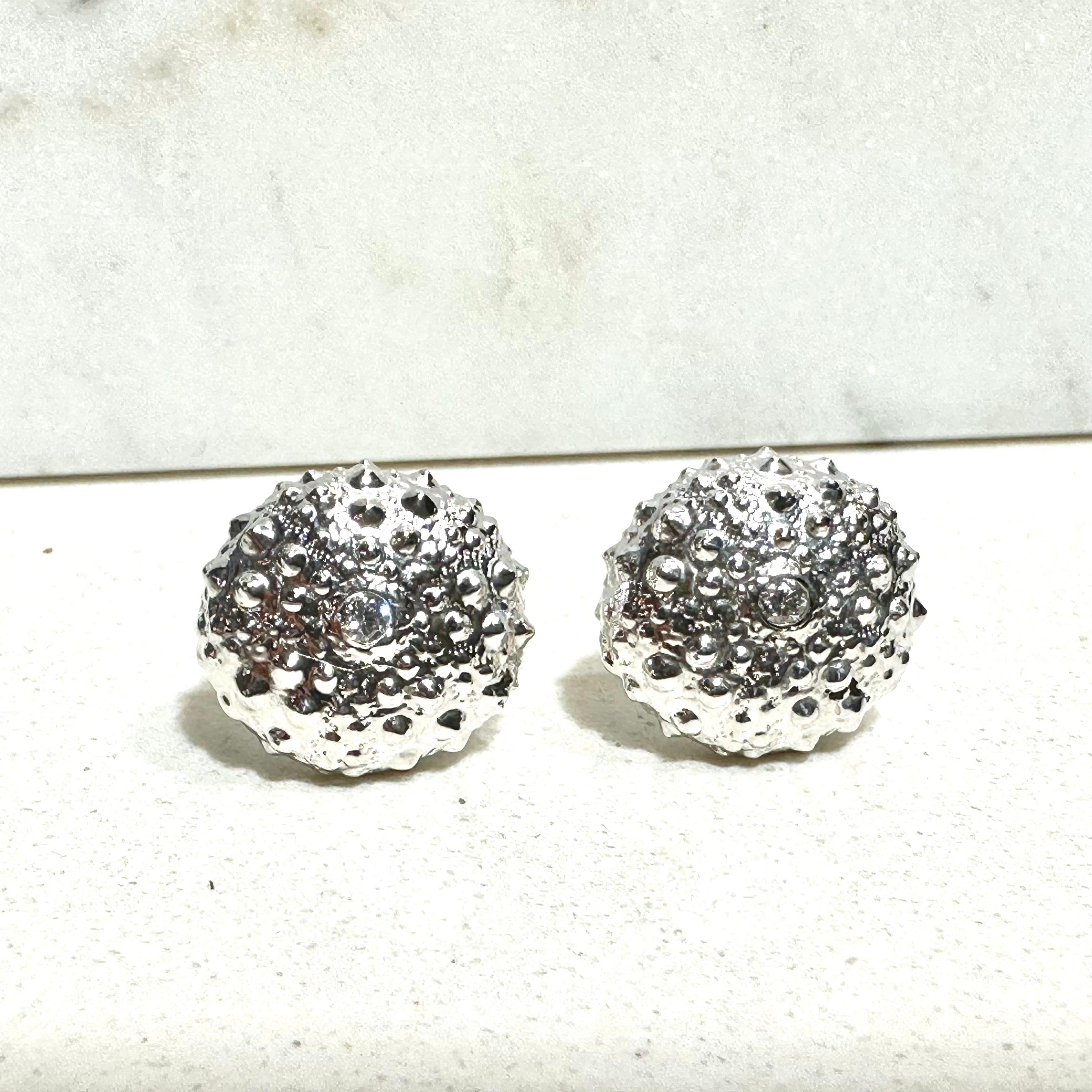 Kristin Hanson's sterling silver sea urchin stud earrings are handcrafted and cast from the natural shell form. With 14k yellow gold posts and sterling silver push back closure. Elegant and earthy treasure perfect for resort and summer looks. 