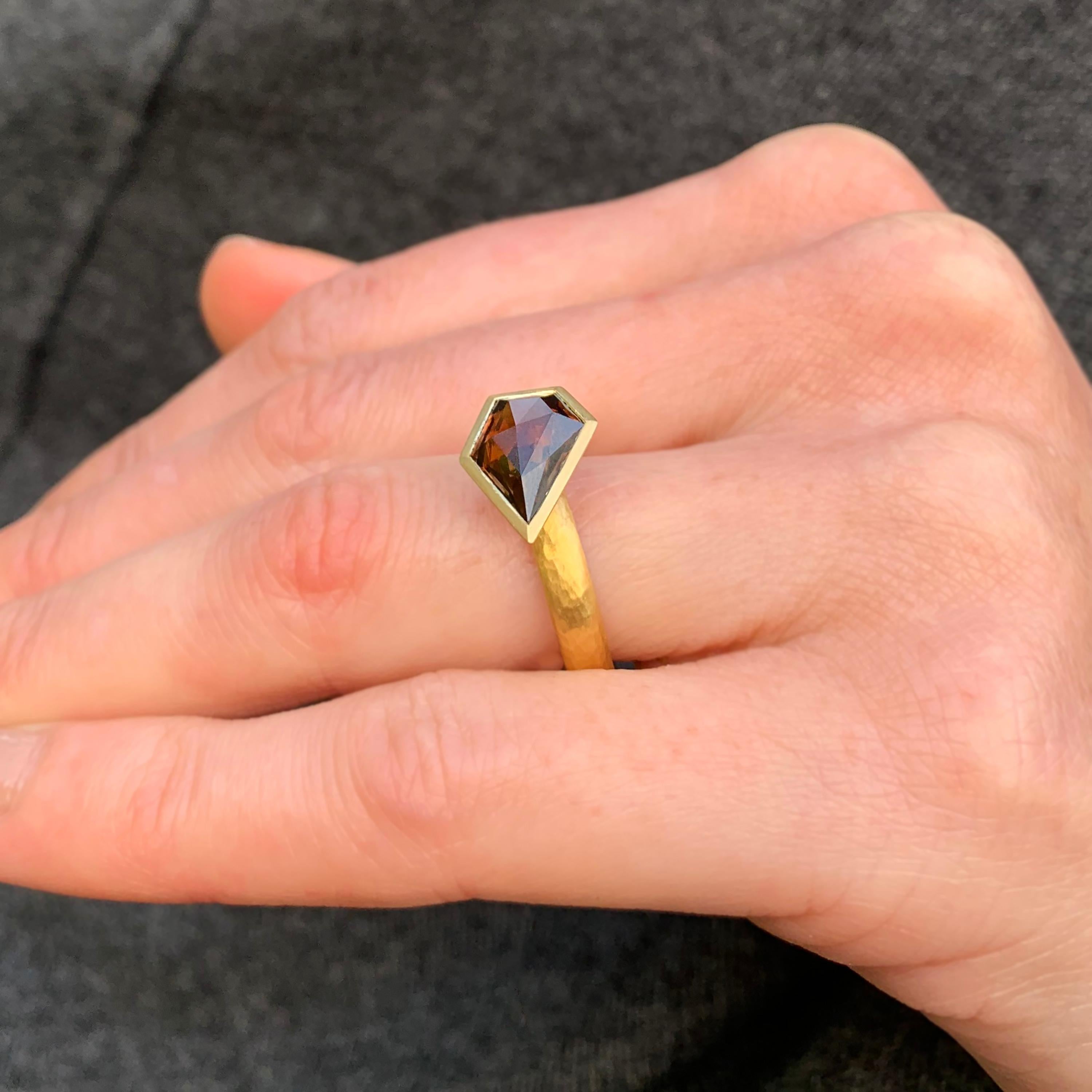 Captivating brown zircon free-form cut by the designer and bezel-set on a substantial gold shank. A beautiful freeform cut Australian zircon (3.75ct) is neatly set in to 18k yellow gold. The contrast of scintillation from the stone and the soft