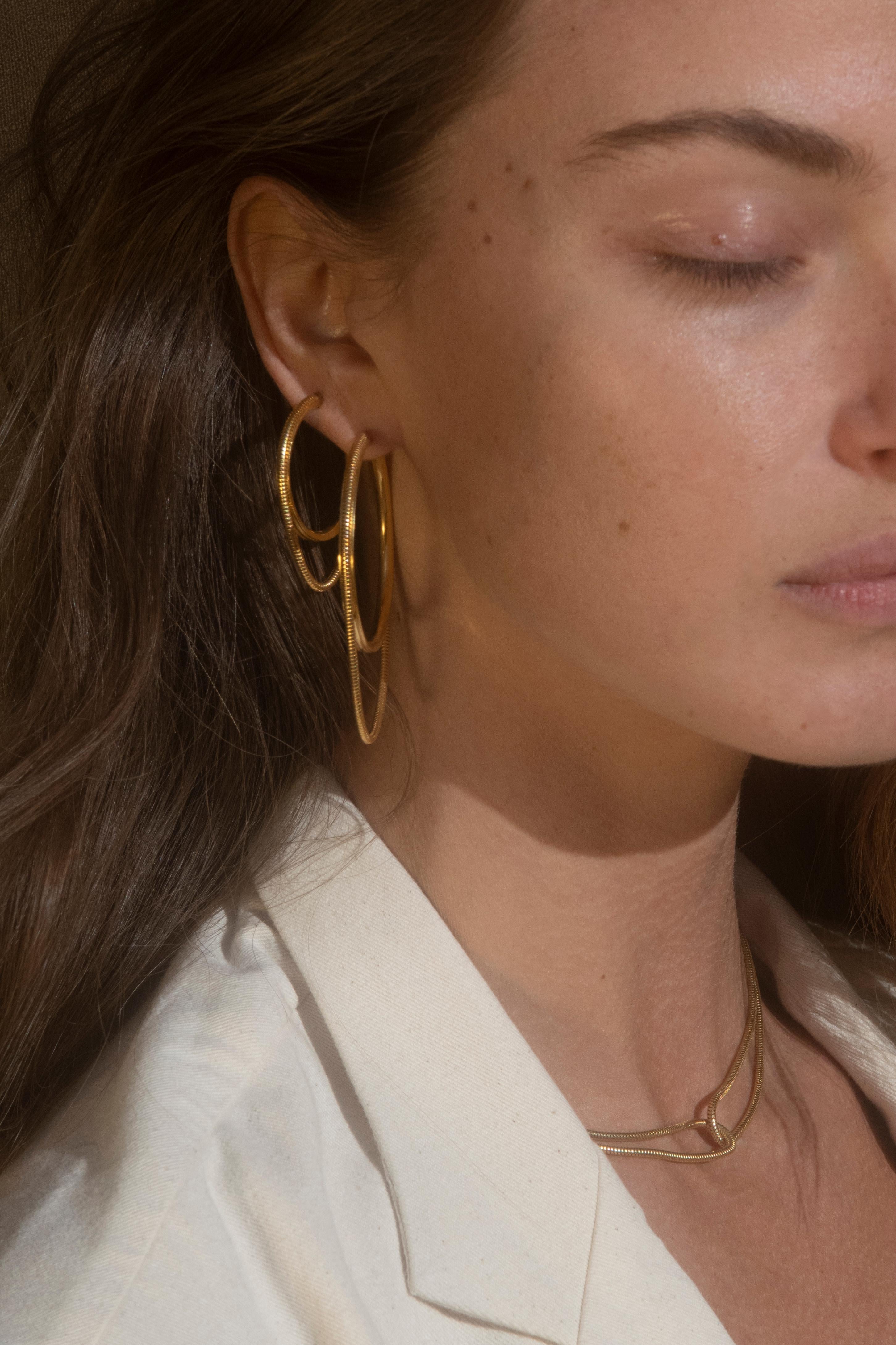 Twinkler Hoops Earrings 

The twinkler small hoops are a combination of a classic and a touch of snake chain that adds movement to your look. These hoops are the perfect size to add just the right amount of shimmer to whatever your wearing. Model is