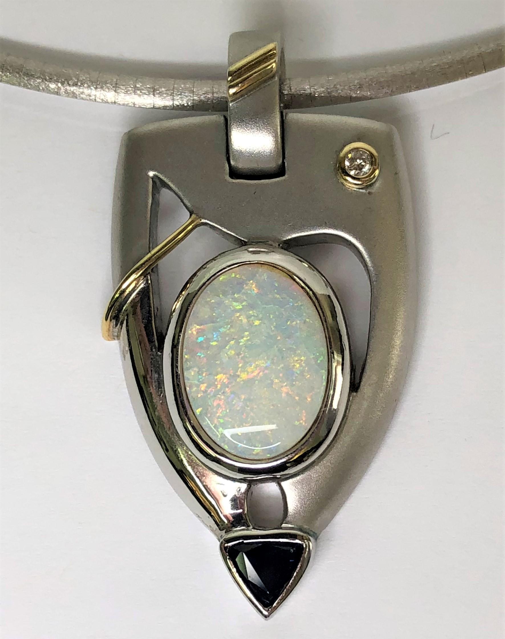 ONE-OF-A-KIND beautifully crafted pendant that makes a statement!
Silver and 18K gold 'arrow' shaped pendant
Oval white opal with red, orange, blue and green play of color, bezel set, approximately 13mm x 10mm.
Round bezel set diamond, approximately