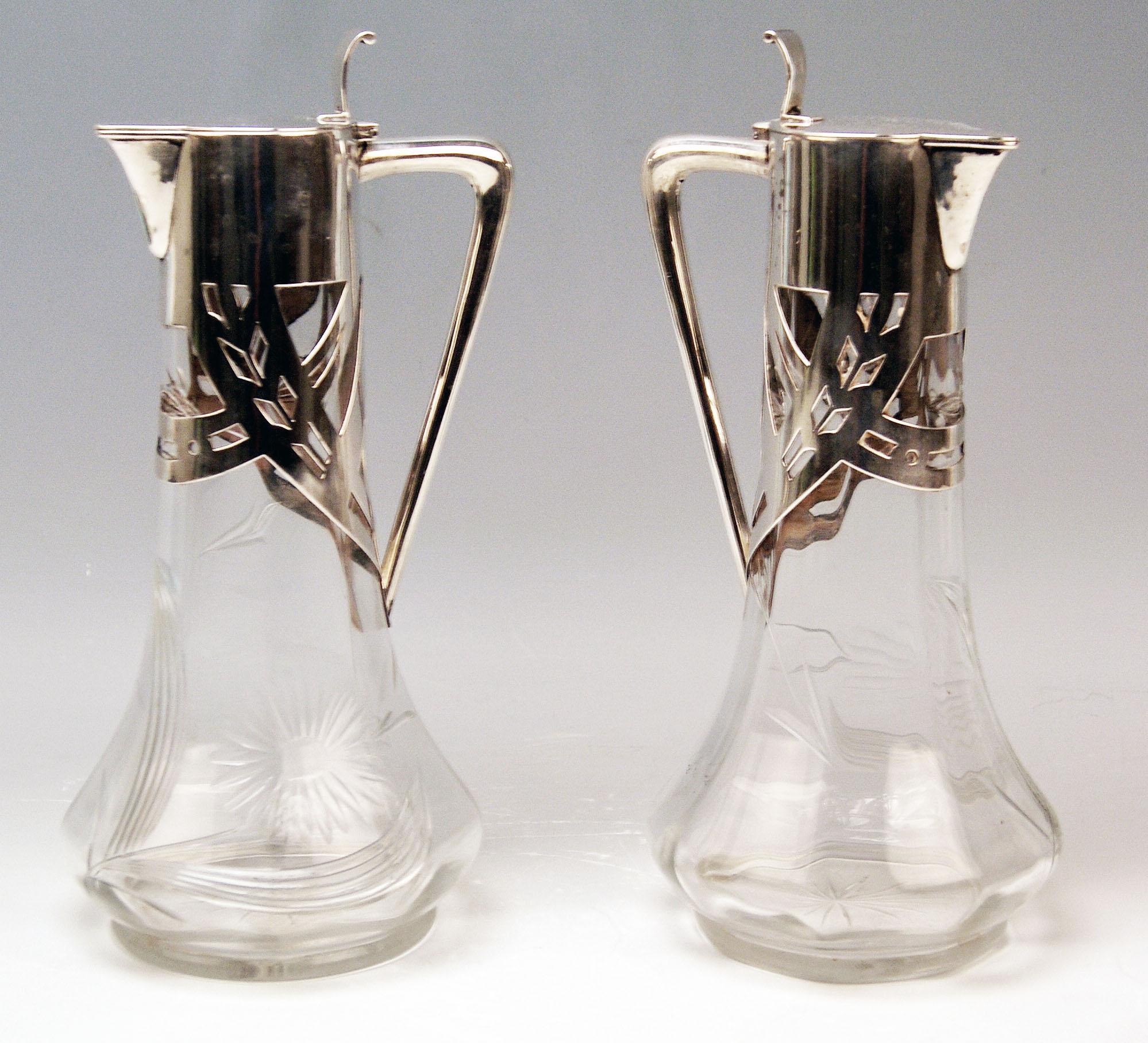Pair of Art Nouveau Glass Decanters (Carafes / Jugs) with Silver Mountings 

Marks:
-- Walking Lion of Firm Deyhle Brothers, Germany / Schwaebisch Gmuend (= manufactory founded 1820) 
-- branded by German Crescent with Crown, used as from year