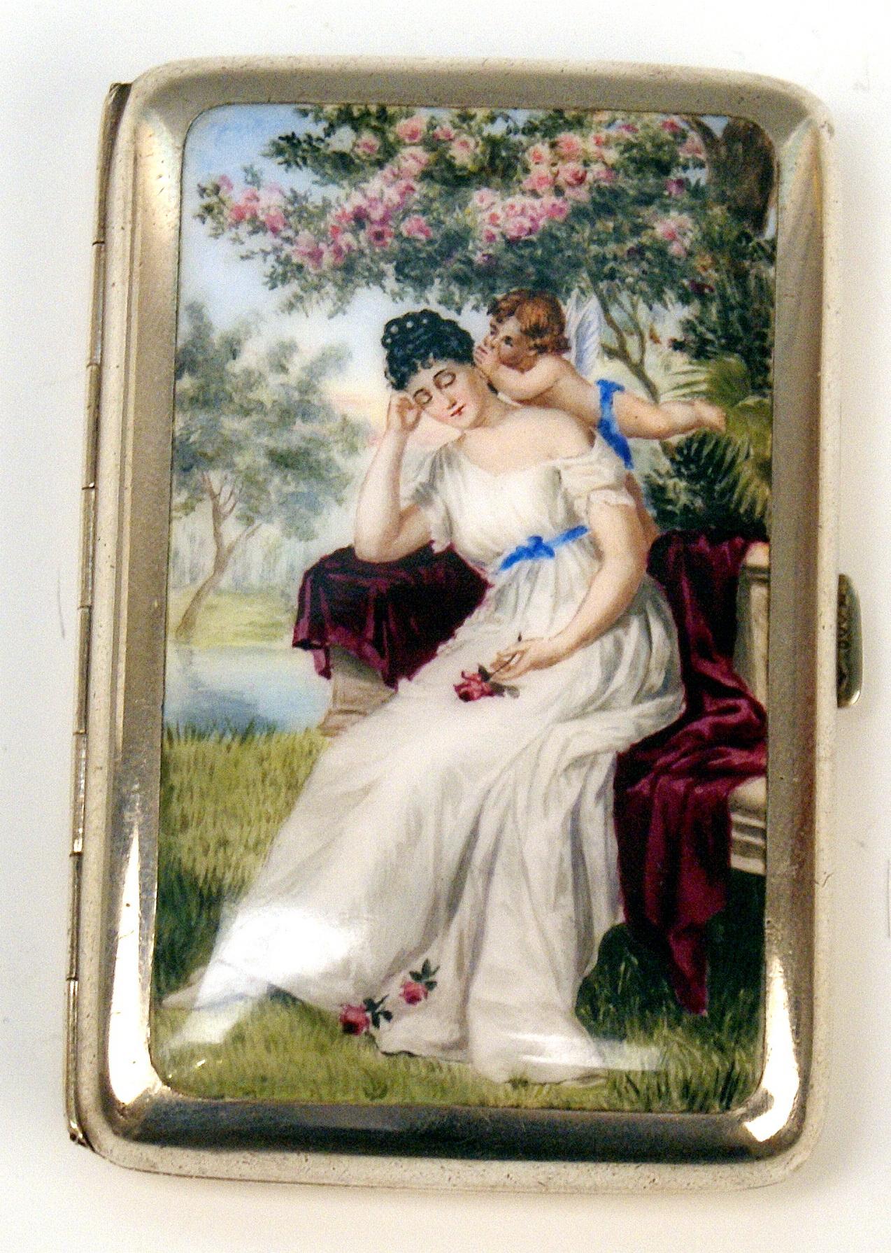 Stunning silver 800 cigarette box / case with enamel painting covering lid:
View of a lady having fallen asleeep - situated in a garden, watched by a winged cherub.

The lid is decorated with a most lovely enamel picture as mentioned