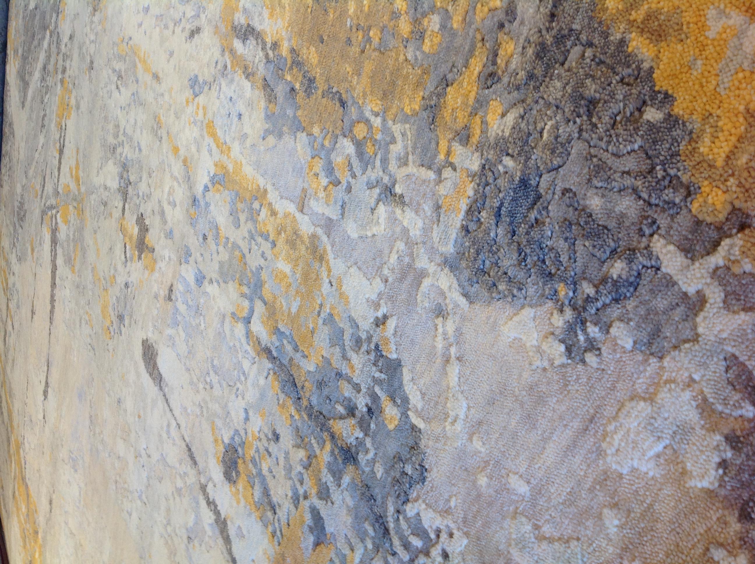 Gold- und elfenbeinfarbene Spritzer auf silbernem Hintergrund in einem schillernden abstrakten Design. Subtile Variationen in der Florhöhe sorgen für den 