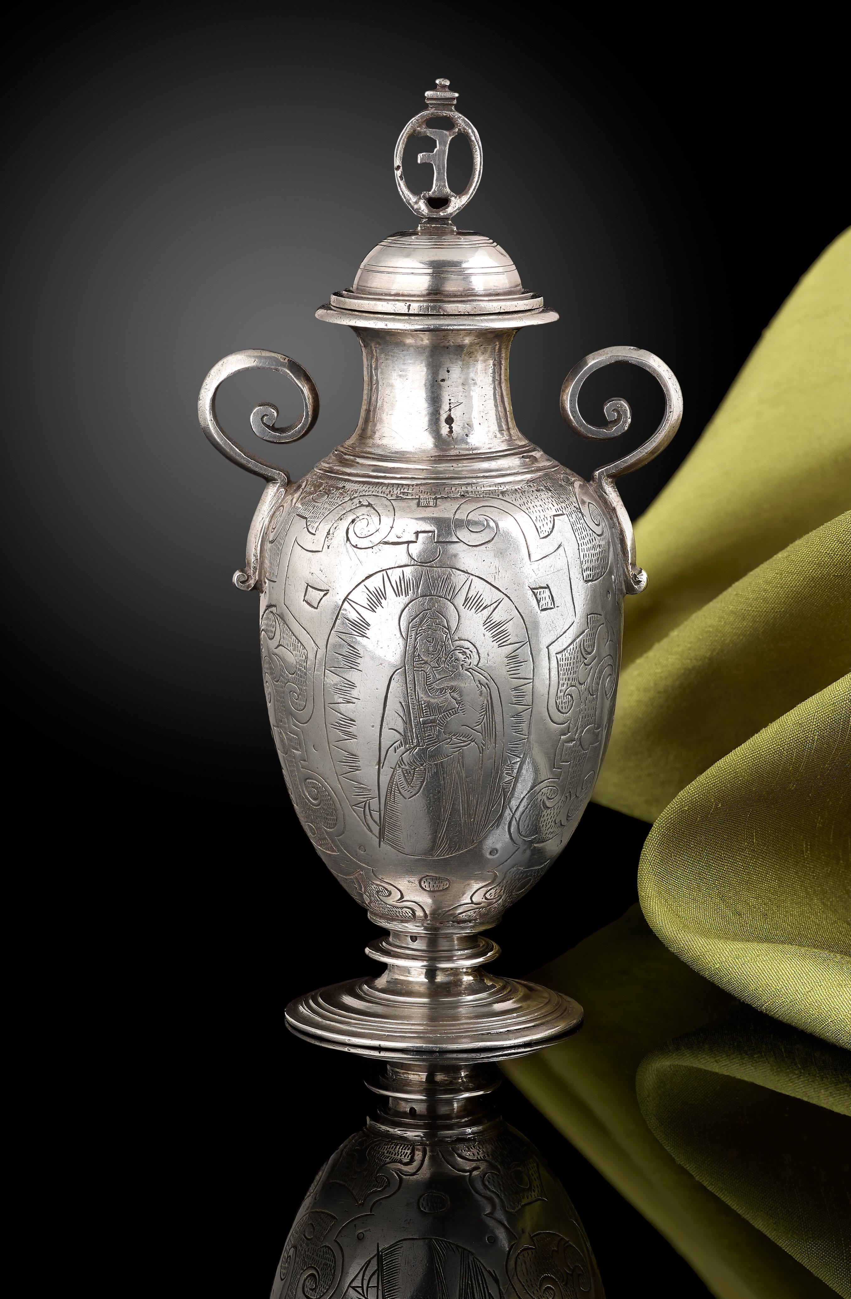 A rare silver altar bottle for holy oil, Spanish, circa 1620, interlocking decoration and two biblical scenes engraved on the sides of the bottle, approximate height to the top of the finial is 5 ½ inches and weighing 6 ozs approximate.