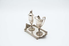 Silver altar cruets set on a base with reliefs