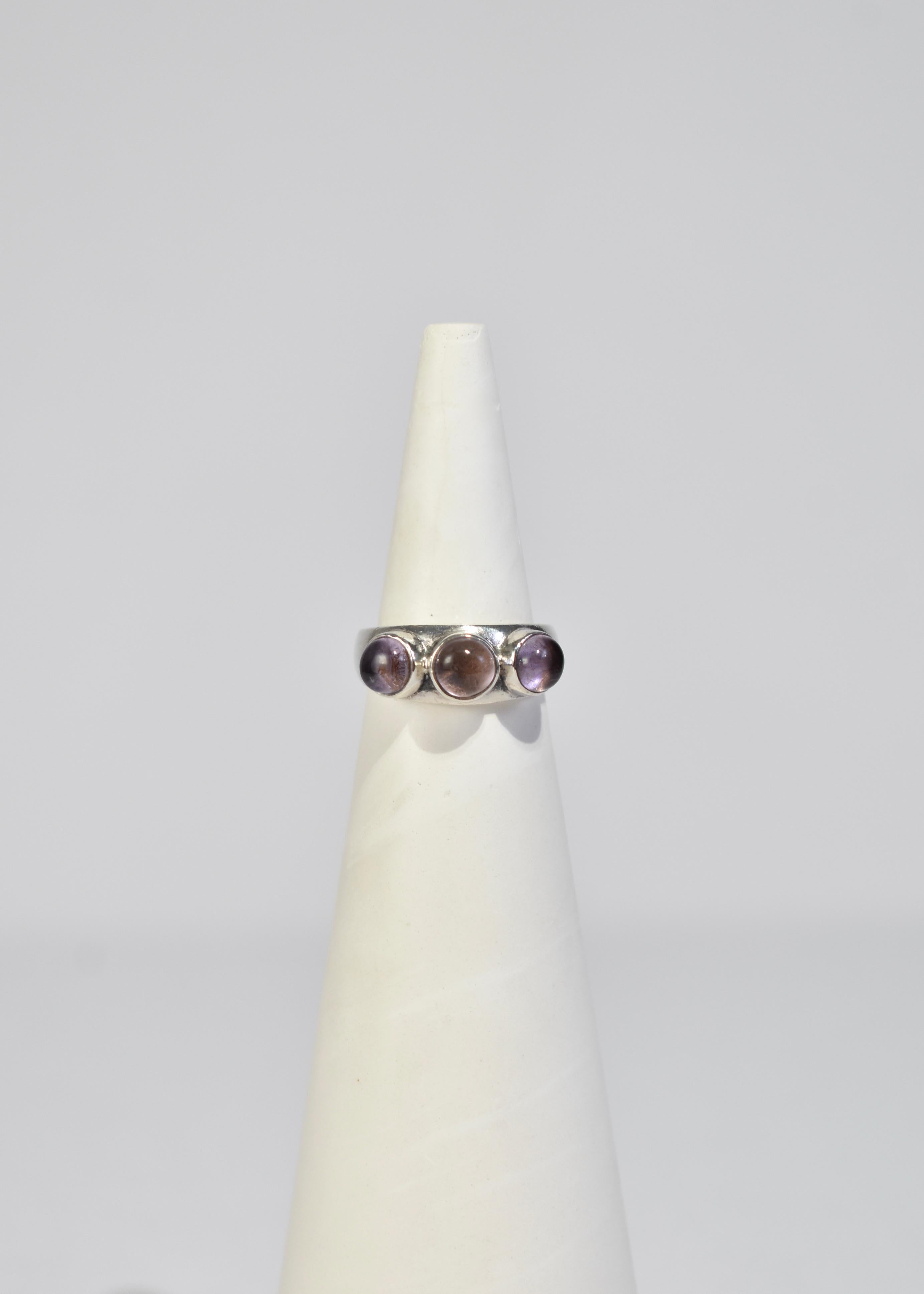 Vintage sterling ring with three polished amethyst cabochons. Stamped 925.

Material: Sterling silver, amethyst.

