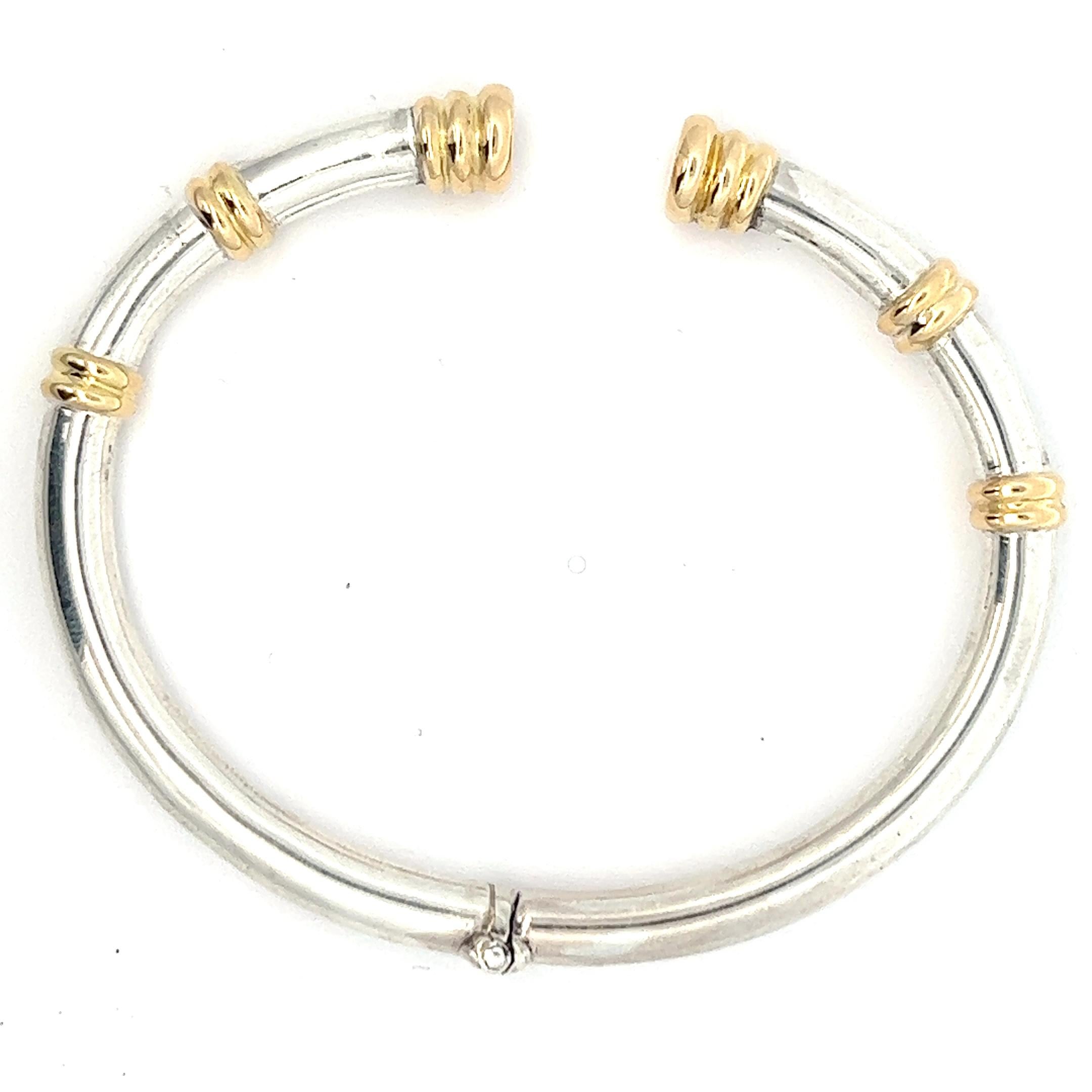 A 925/sterling silver and 18k yellow gold bangle by Lalaounis.
The bangle has an inner diameter of circa 7 cm. 
The bangle is marked with the makers mark for Lalaounis. The bangle is stamped with 750, 925, A21, Greece and Mecan.

This bracelet is