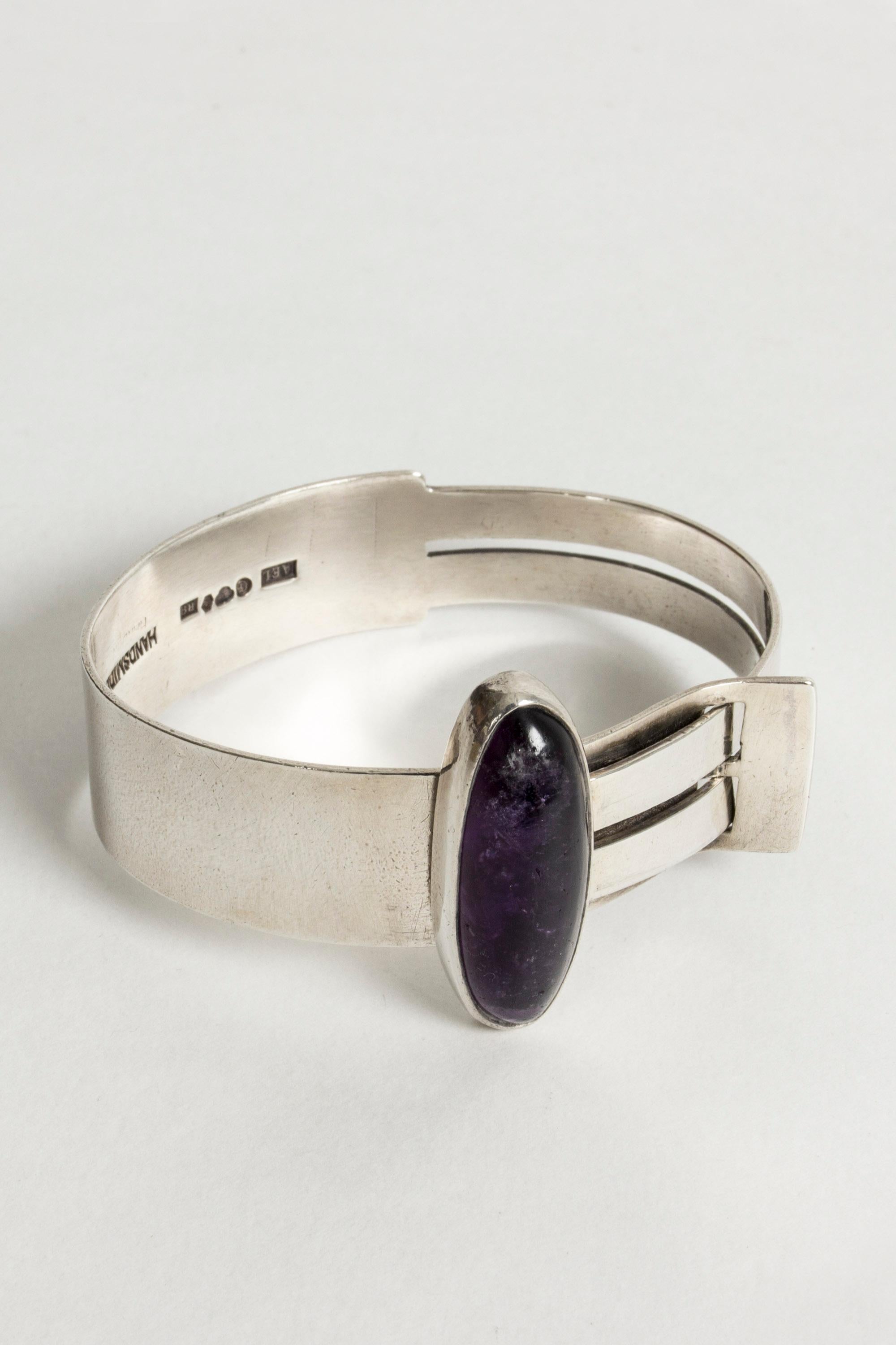 Silver bracelet with a large oval amethyst and an interlocking design by Harry Lagerström. Beautiful deep purple color of the amethyst. Small size, fits a very slender wrist.