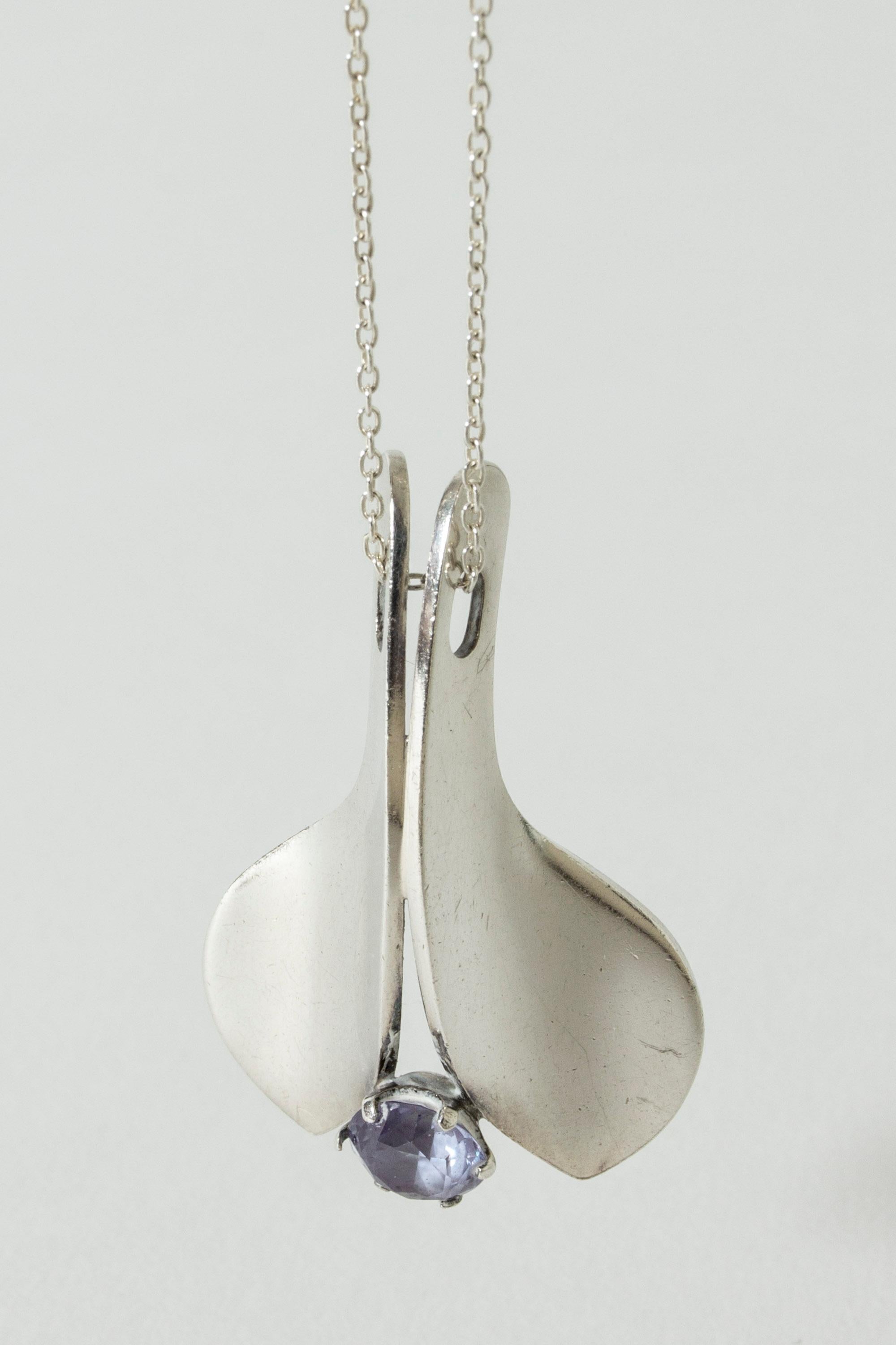 Lovely silver pendant by Elis Kauppi, in a smooth, streamlined design. A sparkly amethyst stone sits in the middle of the cleft.