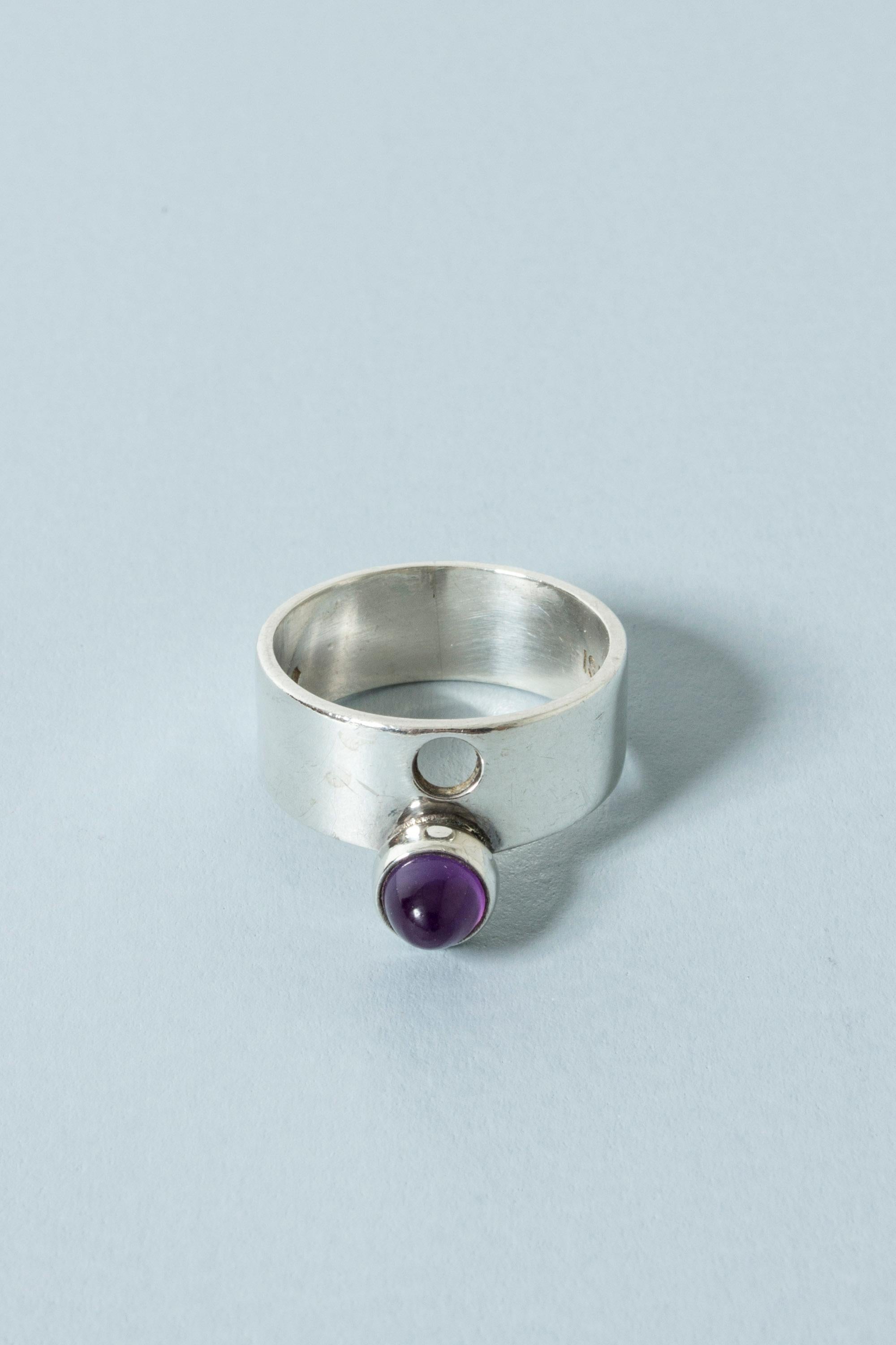 Neat silver ring by Isaac Cohen, with a pointy amethyst stone set on the edge of the of the band. Perforated hole above the stone adds to the cool design.