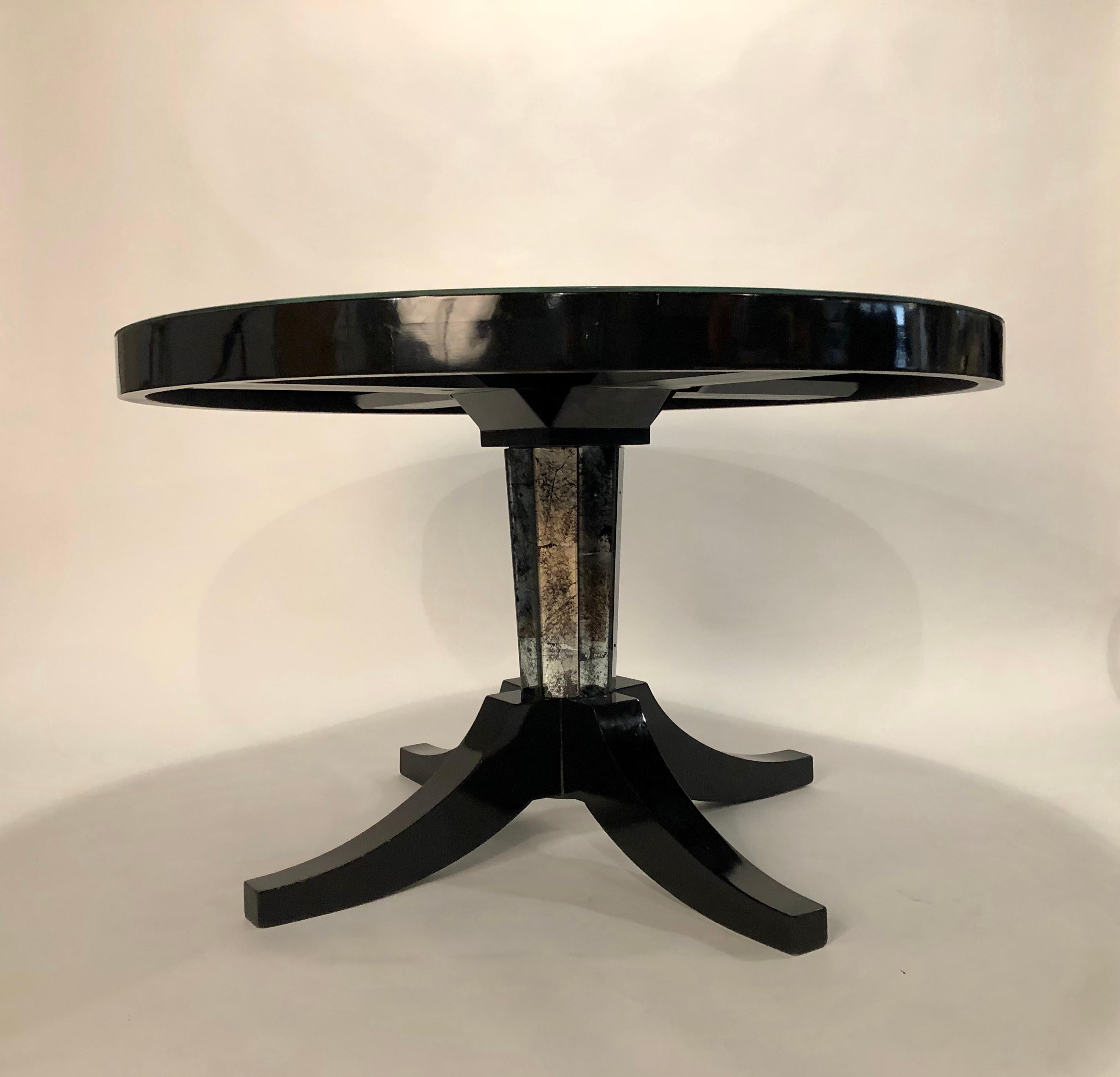 Exquise table Gueridon de la Maison Jansen en laque noire et plateau en miroir argenté/noir. La gorge de la base fait écho au sommet de l'Églomisé.