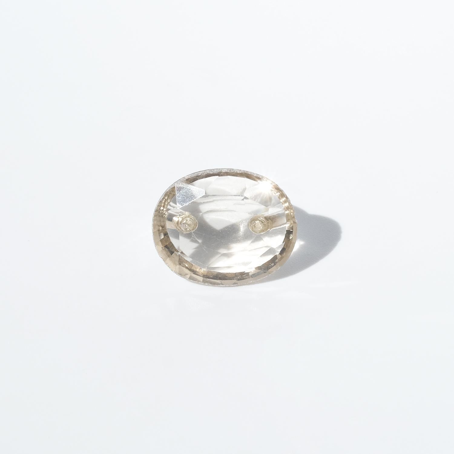 Questo anello presenta un grande citrino dal taglio ovale incastonato su una fascia in argento lucido. Il citrino è trasparente e di colore oro pallido, con sfaccettature visibili che catturano la luce. La sua trasparenza permette di vedere il dito