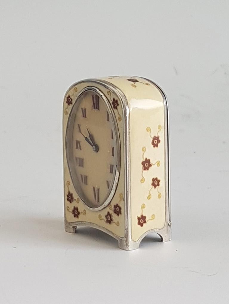 An extremely pretty sub miniature carriage clock. The cream colored enamel decoration to front, sides and top. Overlaying the enamel are hand painted flowers, in red and lemon yellow enamel. The enamel in good condition with no damage. The large