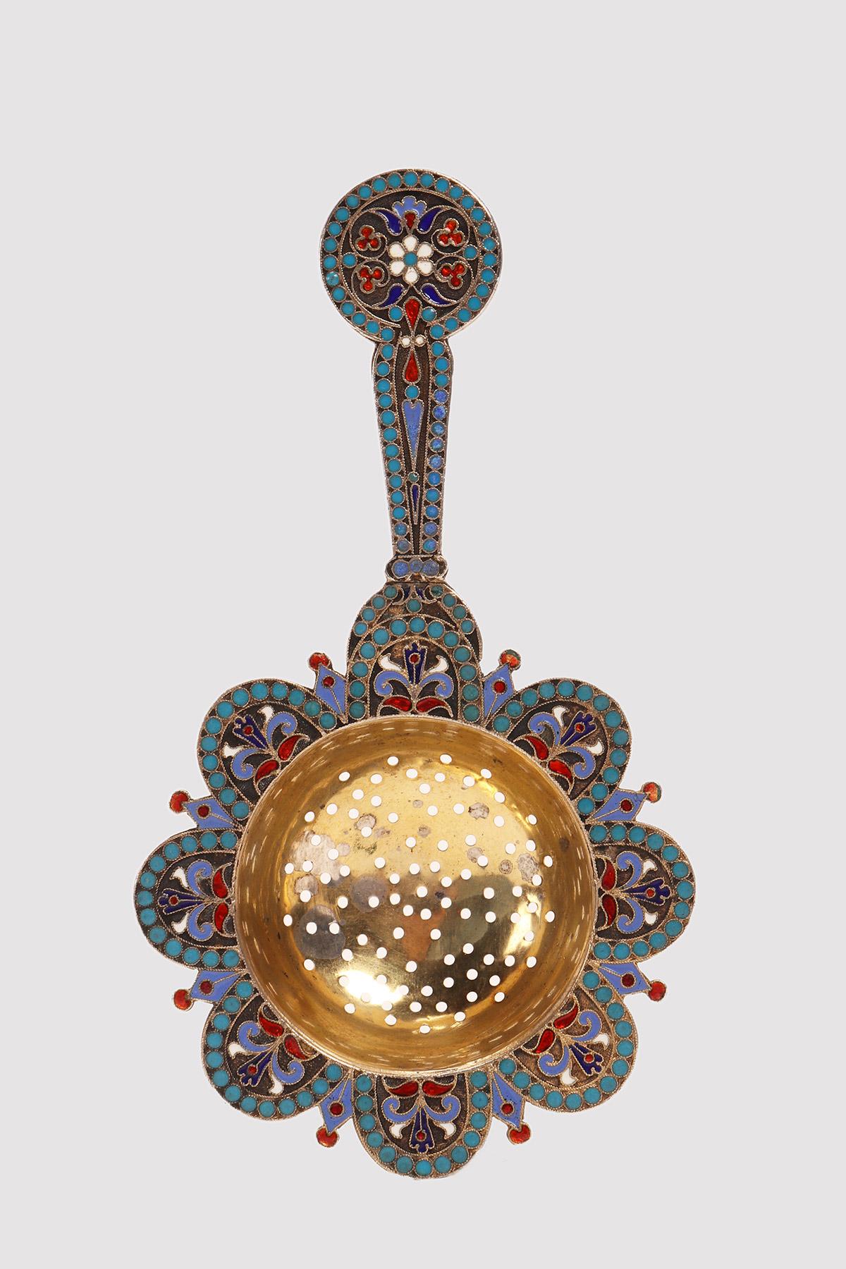 Tea strainer with handle, in 84 Zolotnik silver, gilded and decorated with floral and geometric enamels, cloisonné in white, blue, purple and red. Moscow, Russia, 1884.