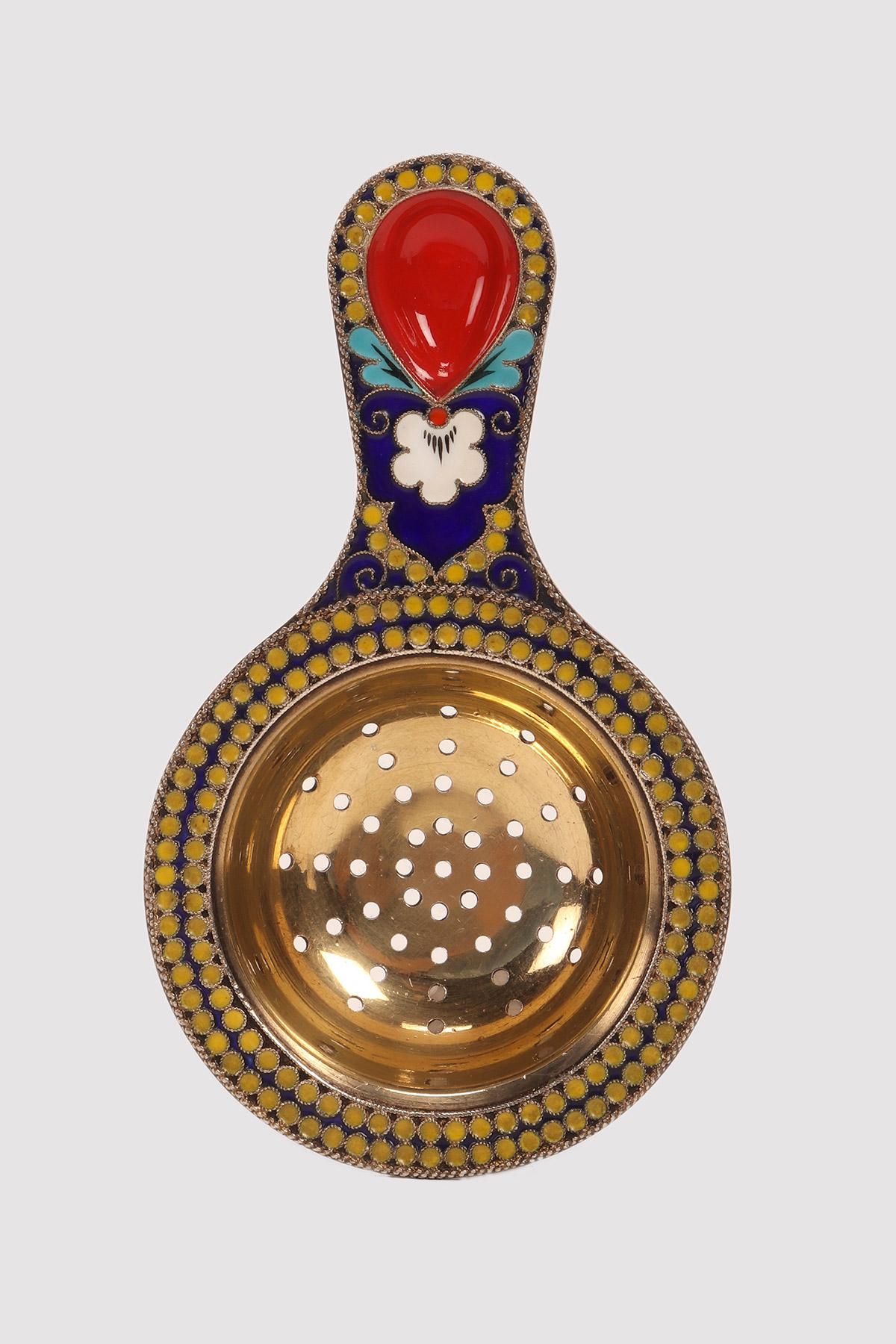 Tea strainer with handle, silver gilded and decorated with yellow, blue and red cloisonné enamels. URSS, circa 1940.