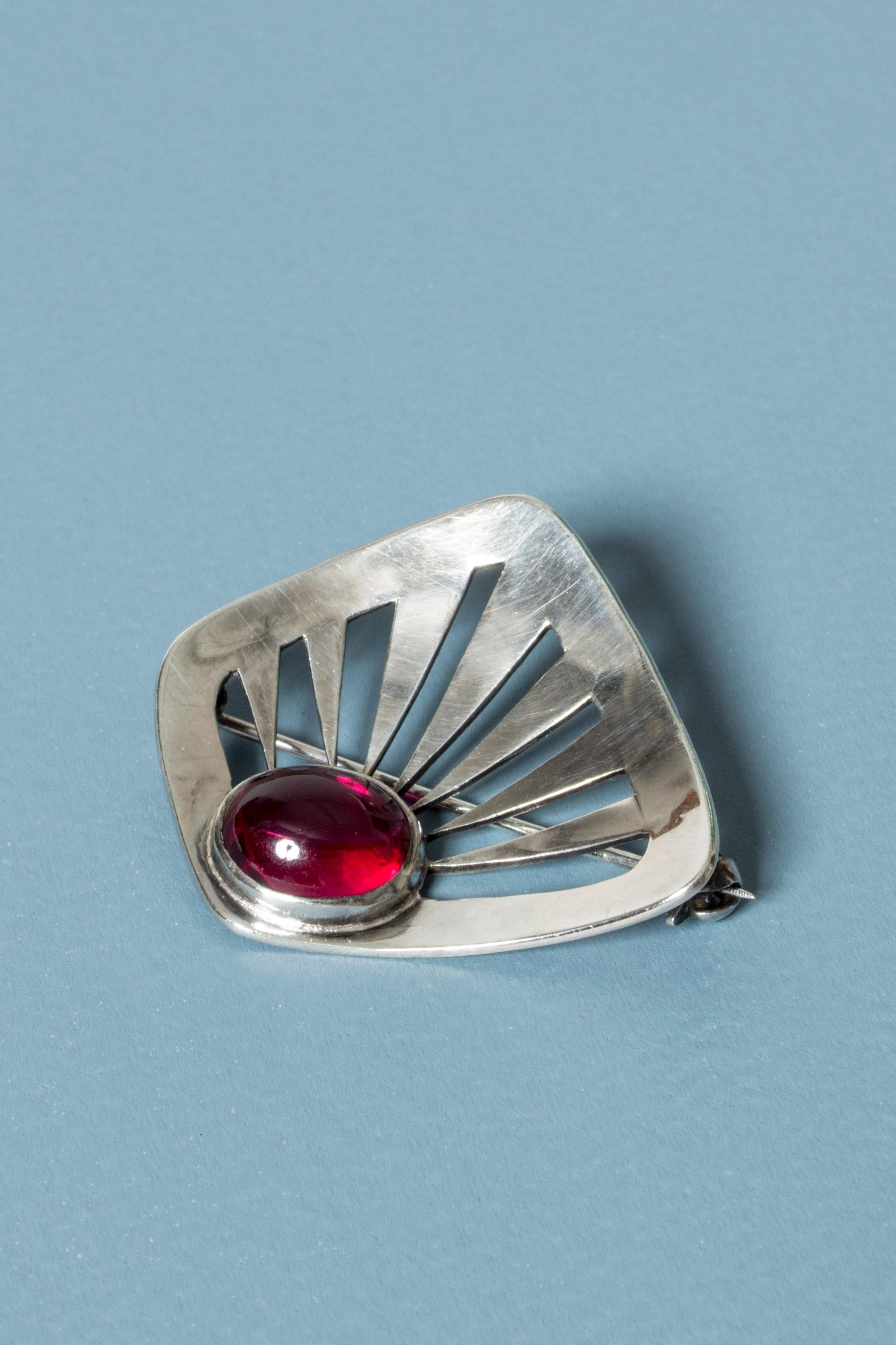 Lovely silver brooch by Rey Urban, with a striking garnet stone. Graphic cut out design of rays coming out from the stone.