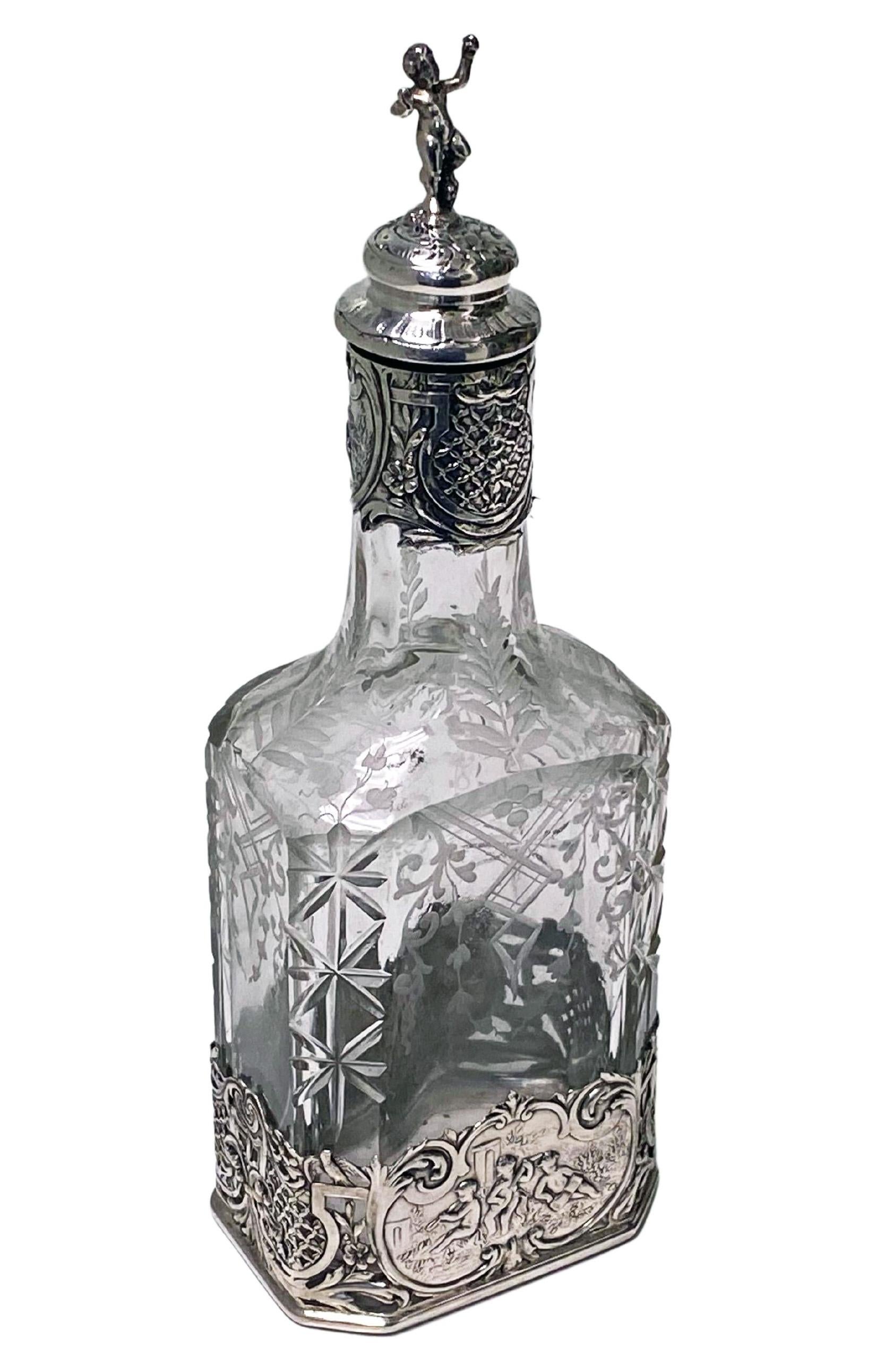 Silver and glass decanter for oil or other dressing, Hanau circa 1890, Storck and Sinsheimer. Octagional cut glass cylindrical neck, double-sided acid-etched foliate motif decoration to the glass. Removeable silver bottom mount with pierced and