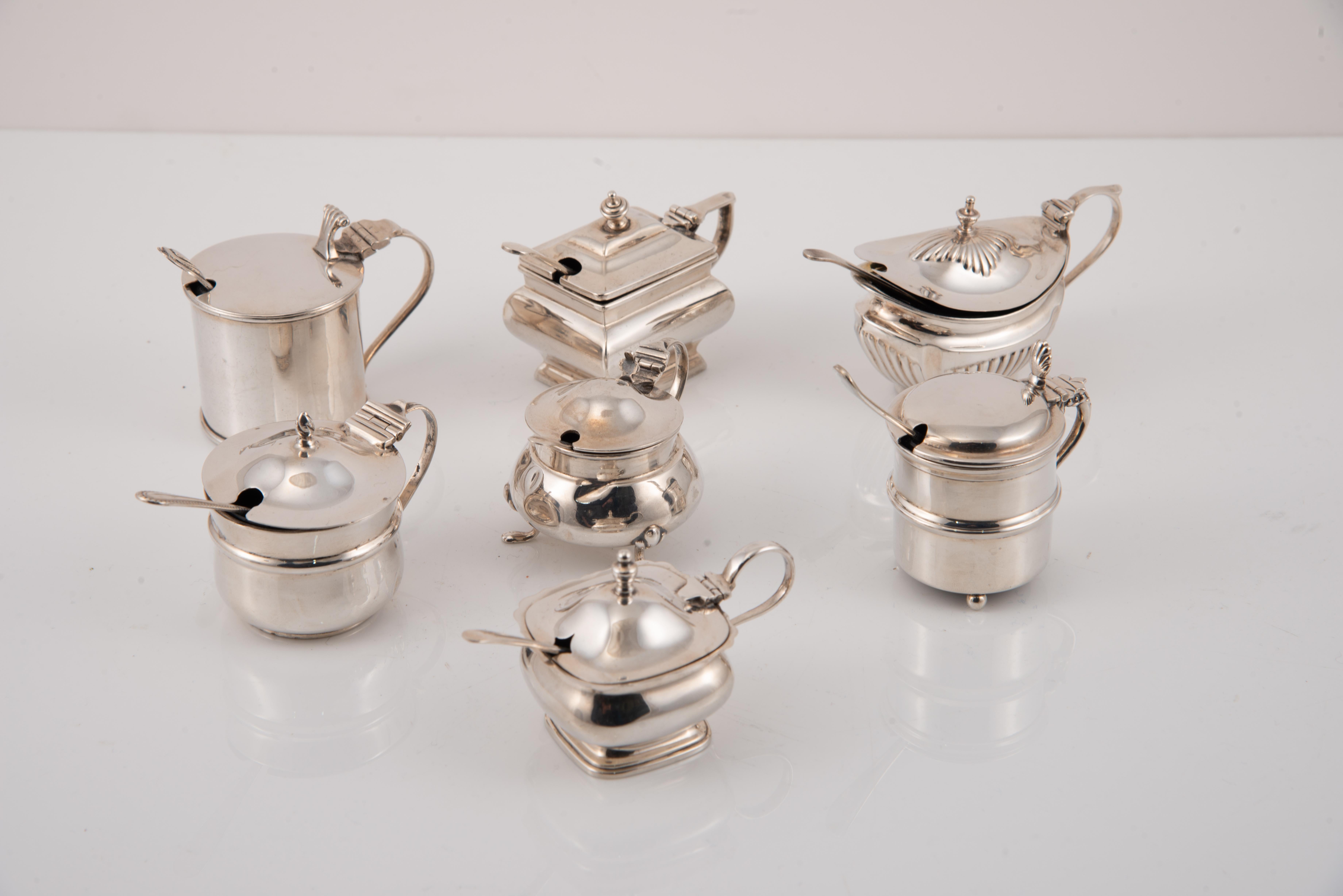Sieben Schnurrbartmacher mit Löffeln. Silber, Glas, etc.etc. England, 20. Jahrhundert. 
Mit Kontrastmarkierungen. 
Versilbertes Besteck mit Glaselementen im Inneren und gestempelt: Henry Hobson & Sons, Birmingham, 1900; möglicherweise E Druiff & Co,