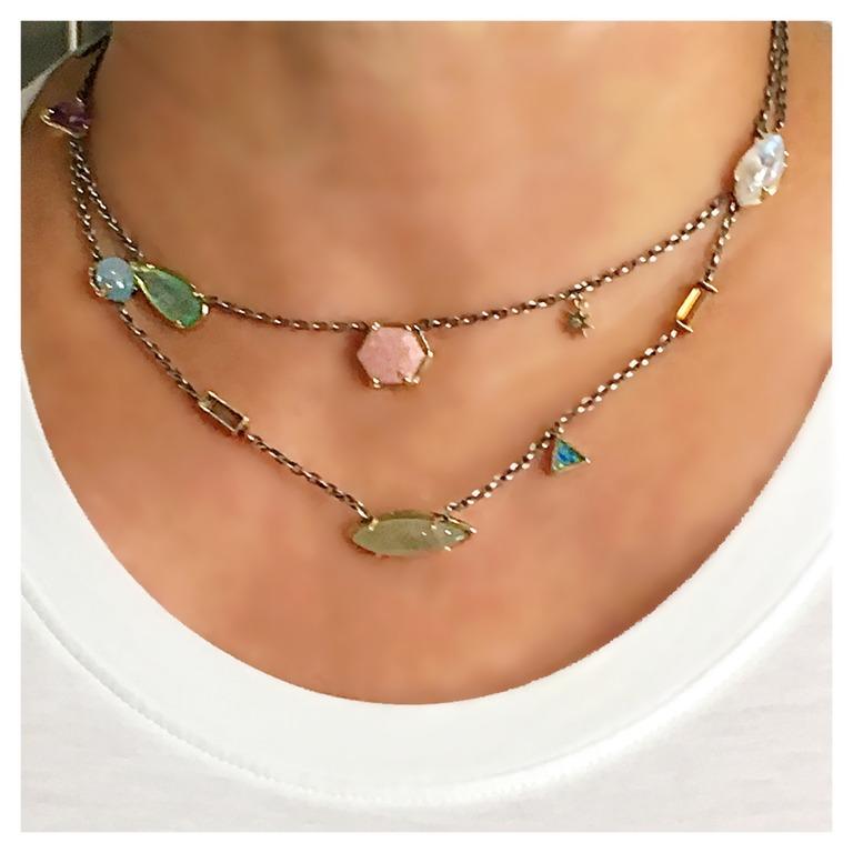 A fashionable and colorful version of a chain necklace.  The oxidized silver chain is interspersed with varied shaped custom cut stones and color.  Each stone is set in 14 Karat gold, and the chain is finished off with our gold star logo charm. This