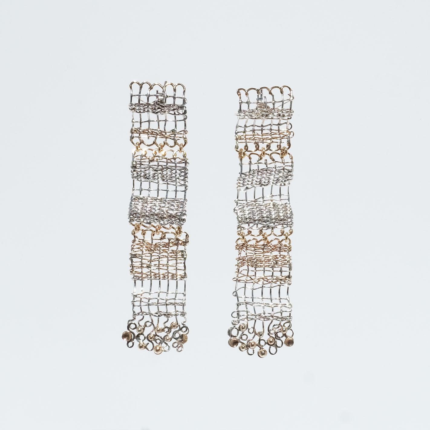 These chandelier earrings are made of sterling silver and 18 karat gold threads that have been intertwined into beautiful dangling ornaments. On the lower part of the earrings, the threads have the shape of something that resembles the eight-shaped