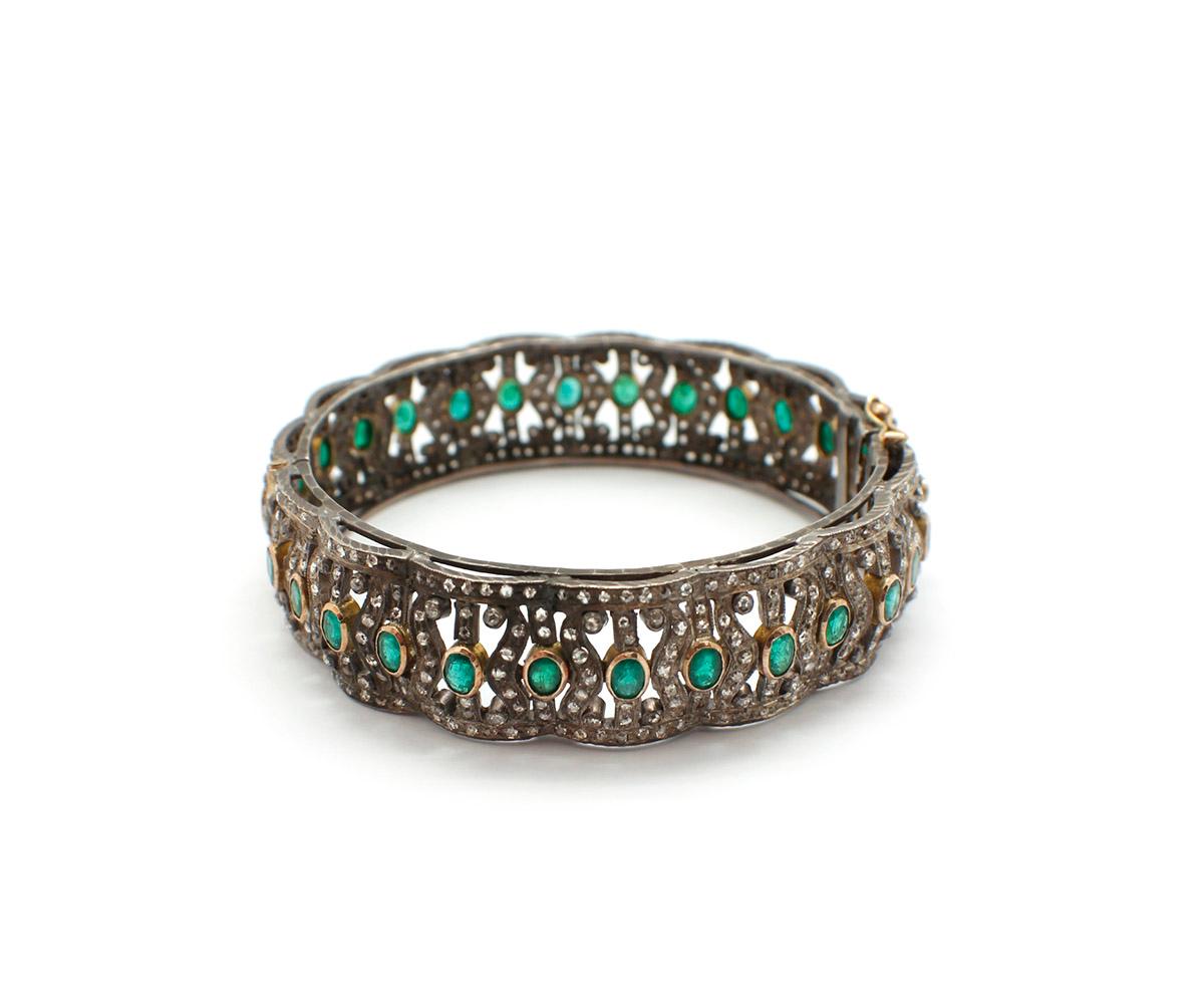 This bracelet is made in silver with gold accents. The bracelet is set with 540 rose cut diamonds alongside a total of 30 stunning oval-cut emeralds. The diamonds have a total weight of about 5 carats, and the emeralds weigh about 3 carats total.